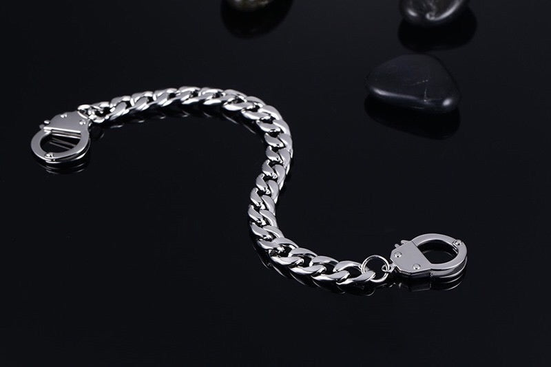 Curb handcuff bracelet made of stainless steel, featuring a sleek curb chain design and adjustable length.