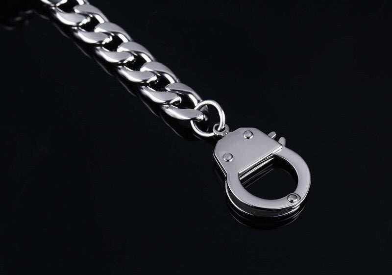 Curb handcuff bracelet made of stainless steel, featuring a sleek curb chain design and adjustable length.