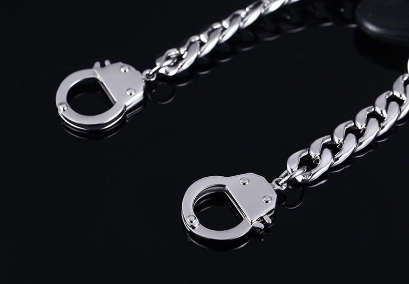 Curb handcuff bracelet made of stainless steel, featuring a sleek curb chain design and adjustable length.