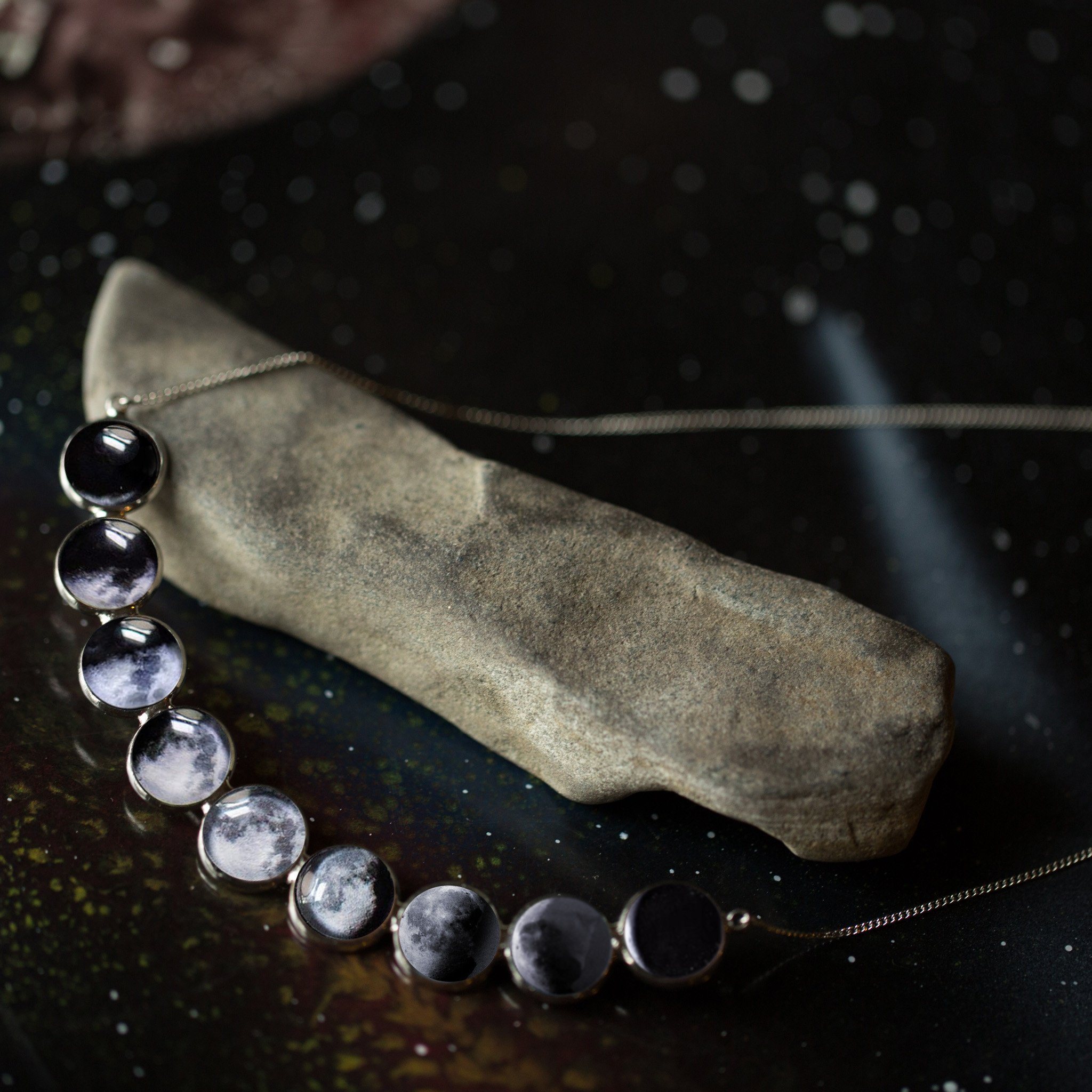 Curved Moon Phase Necklace in Silver showcasing nine lunar phases in handcrafted bezels, perfect for stargazers and moon lovers.