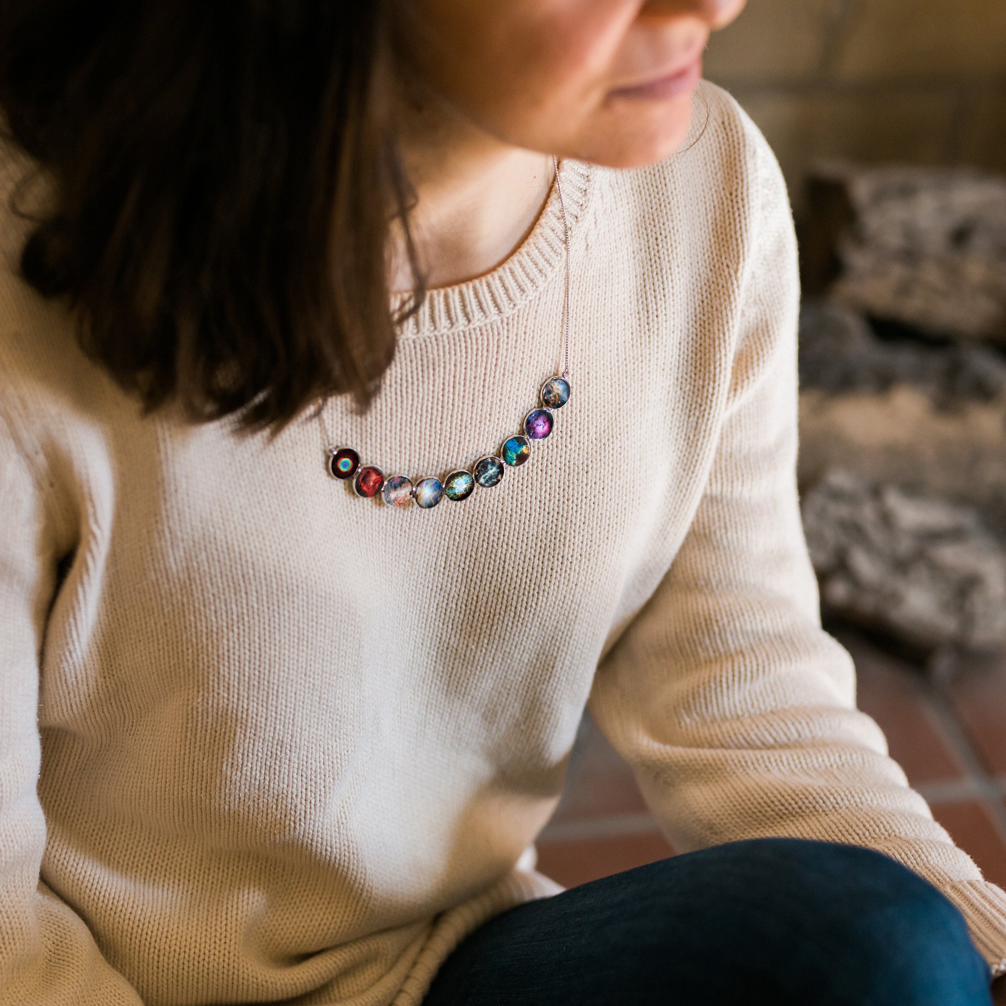 Curved Nebula Rainbow Necklace in Silver featuring nine colorful nebulae designs in silver bezels, perfect for stargazers.