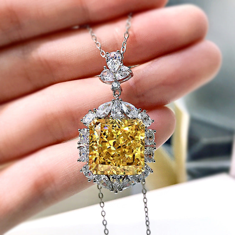 A stunning cushion cut fancy yellow citrine necklace set in 925 sterling silver with white gold accents, featuring brilliant white sapphires.