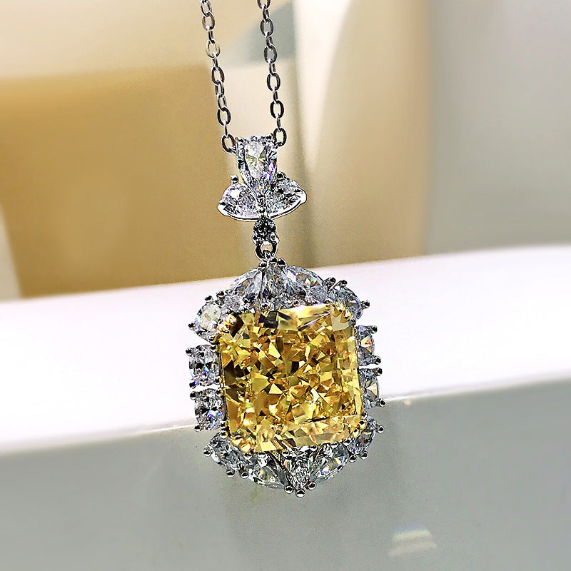 A stunning cushion cut fancy yellow citrine necklace set in 925 sterling silver with white gold accents, featuring brilliant white sapphires.