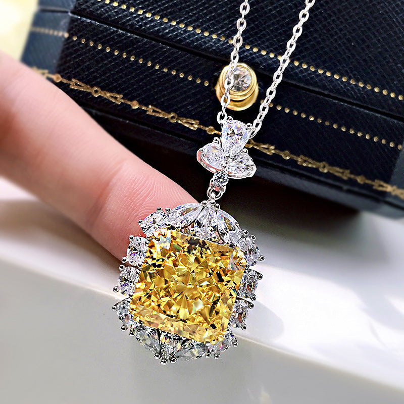 A stunning cushion cut fancy yellow citrine necklace set in 925 sterling silver with white gold accents, featuring brilliant white sapphires.