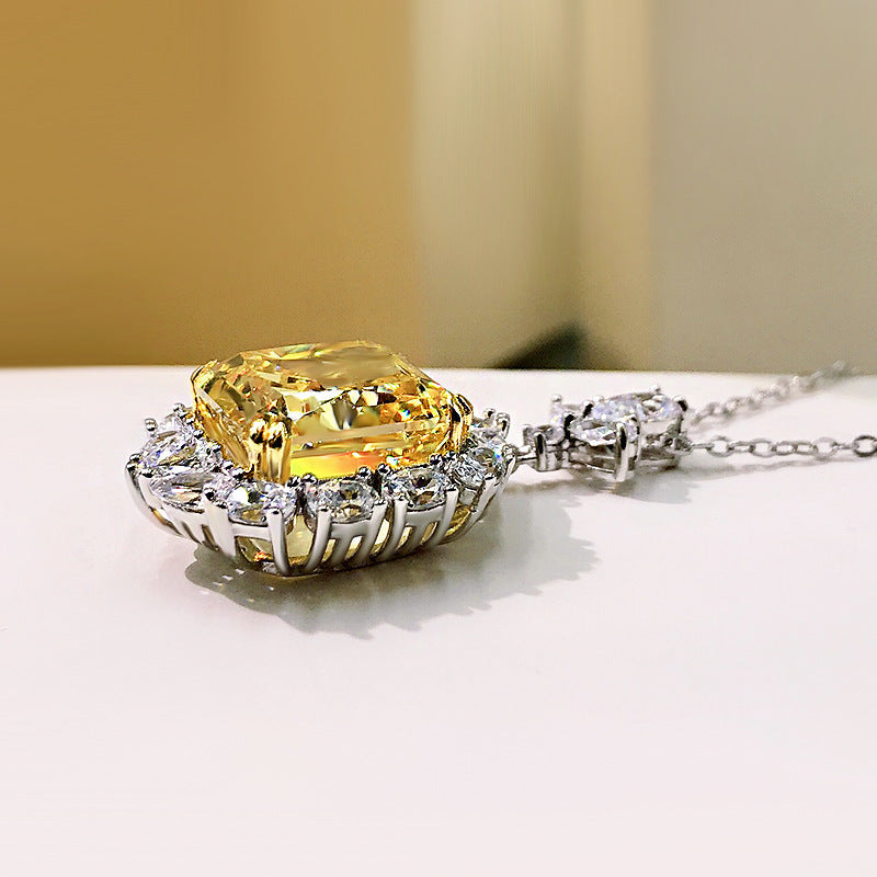 A stunning cushion cut fancy yellow citrine necklace set in 925 sterling silver with white gold accents, featuring brilliant white sapphires.