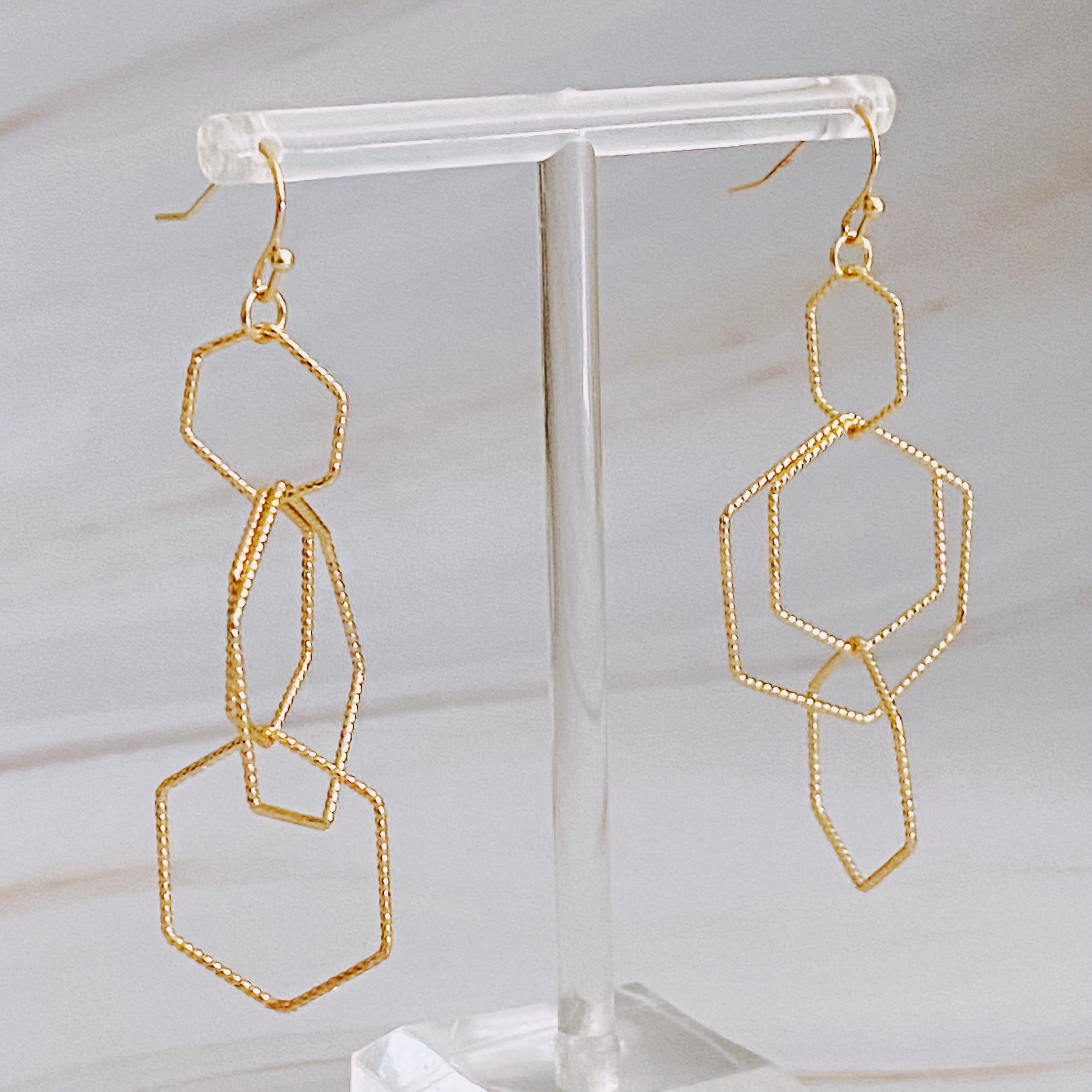 Dainty Dimensional Drop Earrings featuring hexagon designs in gold plated alloy, showcasing a beautiful shine and lightweight construction.