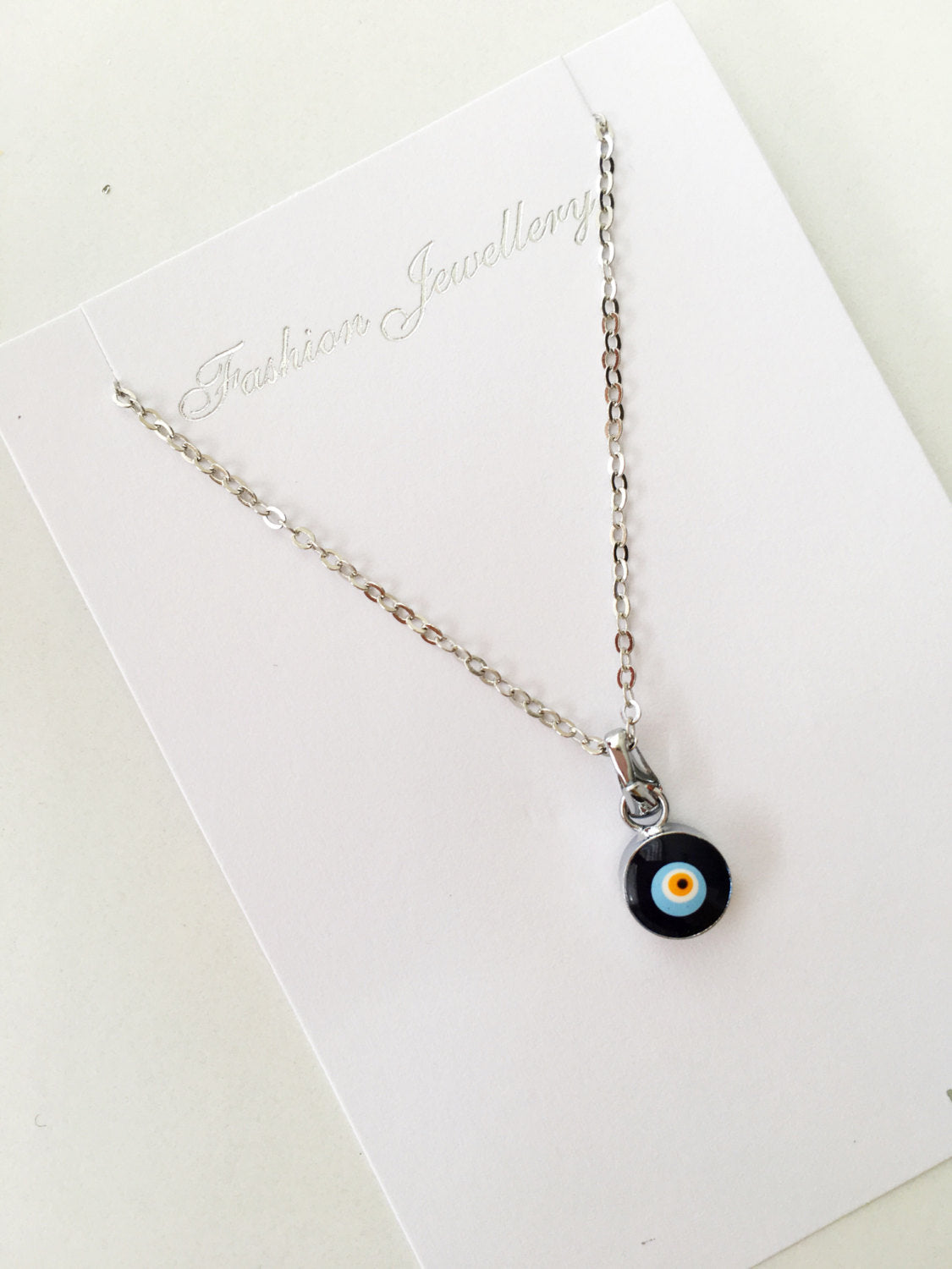 Handmade Dainty Evil Eye Necklace featuring blue glass beads and a silver chain, symbolizing protection and style.