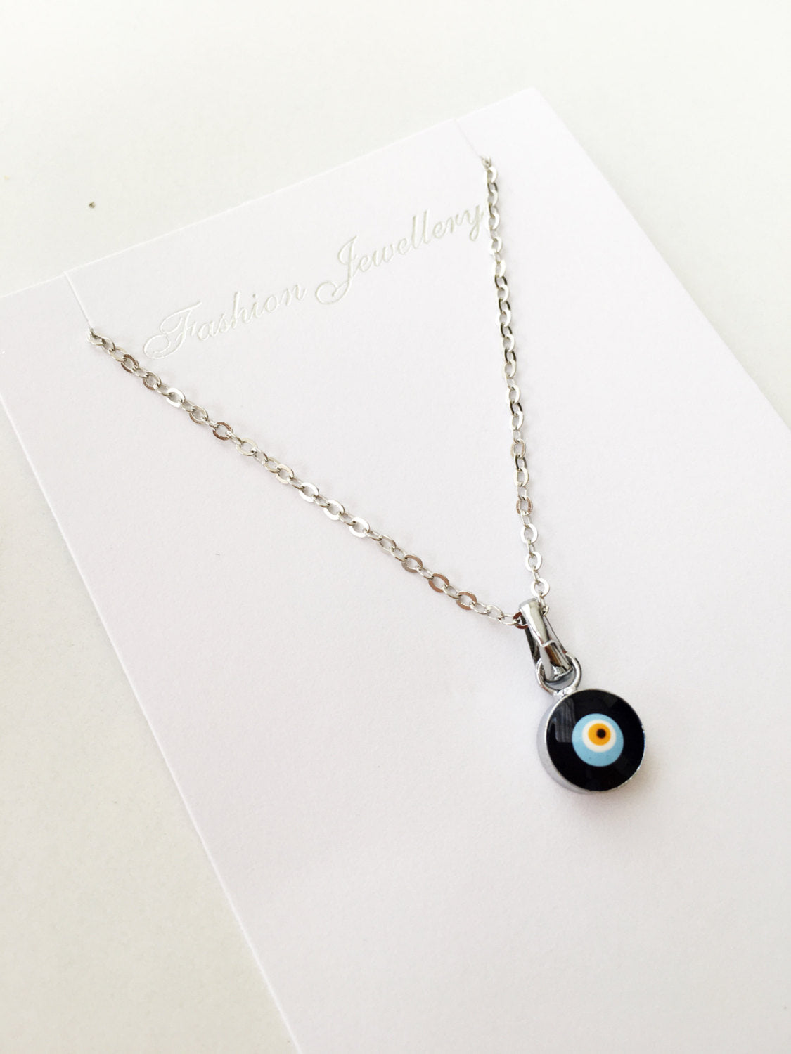 Handmade Dainty Evil Eye Necklace featuring blue glass beads and a silver chain, symbolizing protection and style.