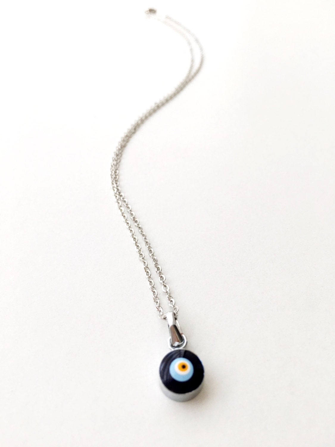 Handmade Dainty Evil Eye Necklace featuring blue glass beads and a silver chain, symbolizing protection and style.