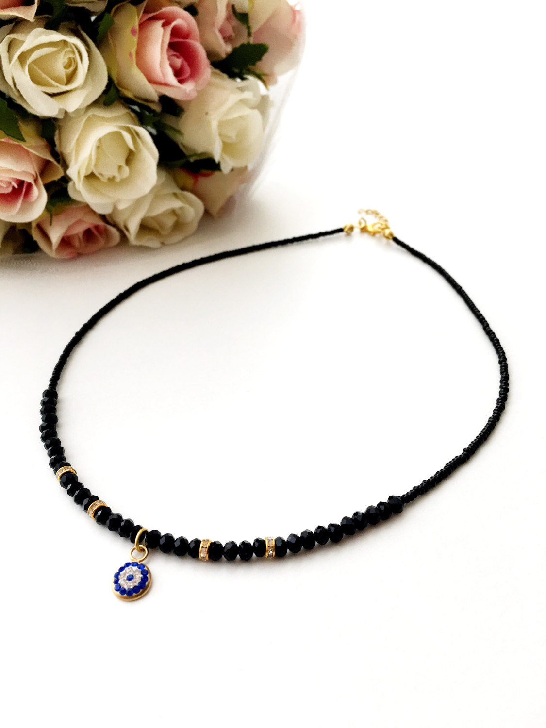 Dainty Evil Eye Necklace featuring black seed beads and a minimalist design, adjustable chain length, available in rose or gold plating.