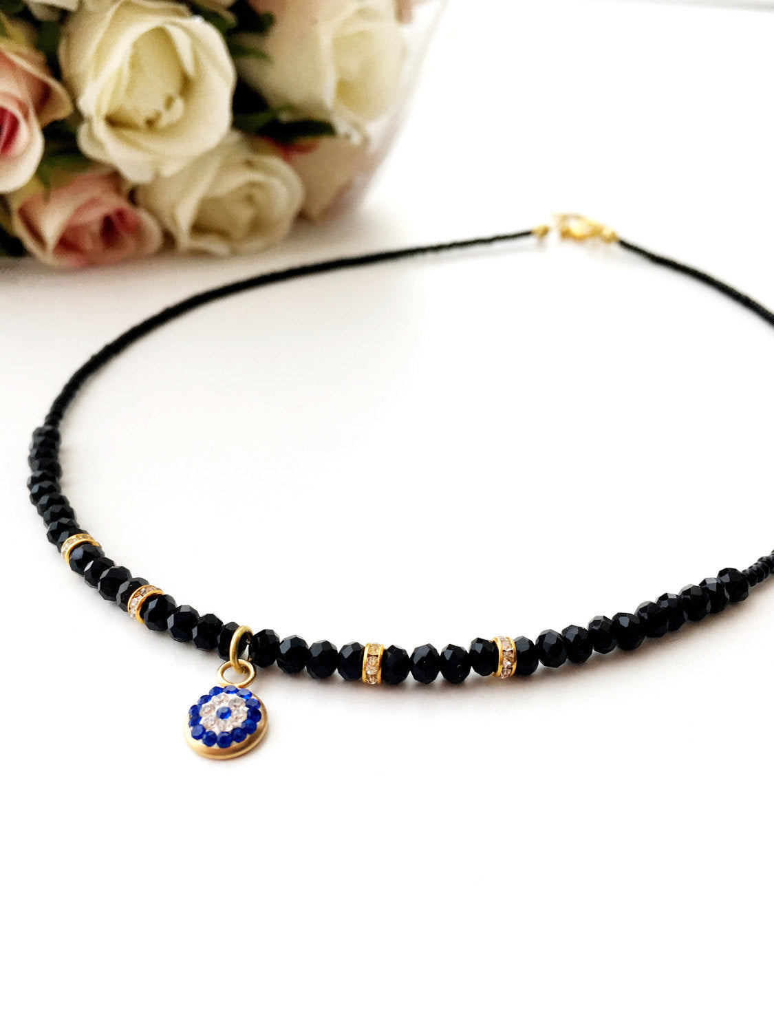 Dainty Evil Eye Necklace featuring black seed beads and a minimalist design, adjustable chain length, available in rose or gold plating.