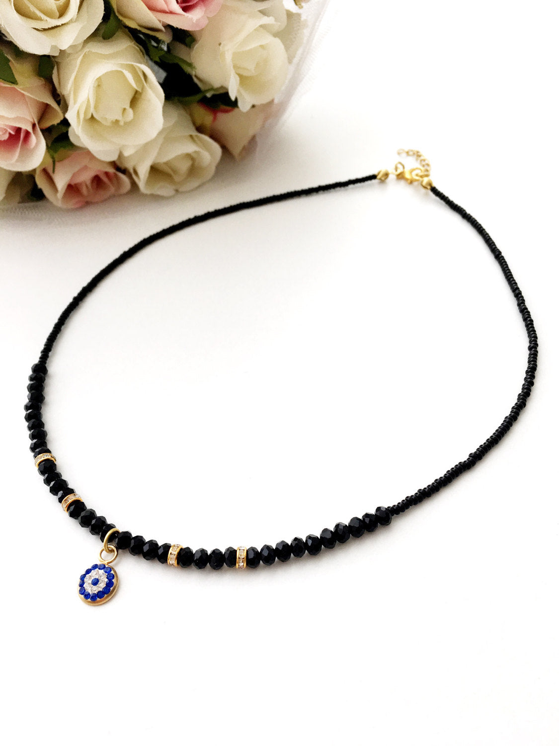 Dainty Evil Eye Necklace featuring black seed beads and a minimalist design, adjustable chain length, available in rose or gold plating.