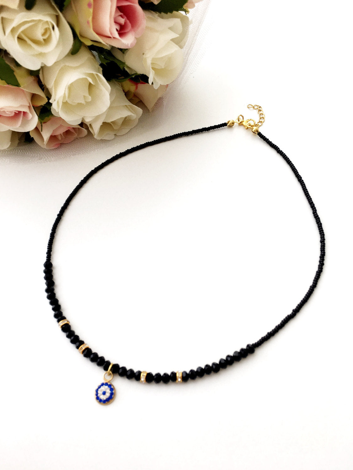 Dainty Evil Eye Necklace featuring black seed beads and a minimalist design, adjustable chain length, available in rose or gold plating.