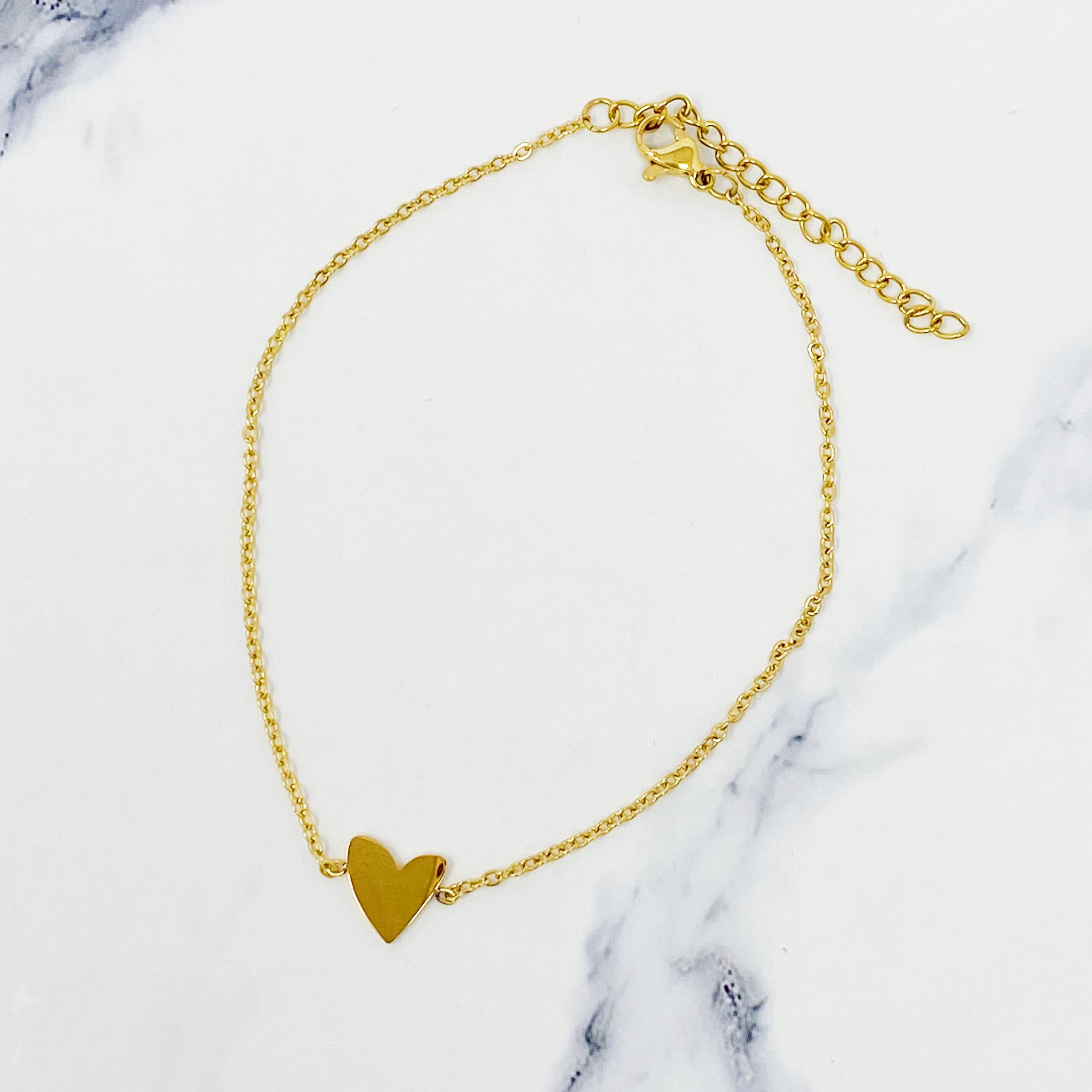 A delicate gold plated stainless steel anklet featuring a polished heart charm, perfect for stylish ankle adornment.