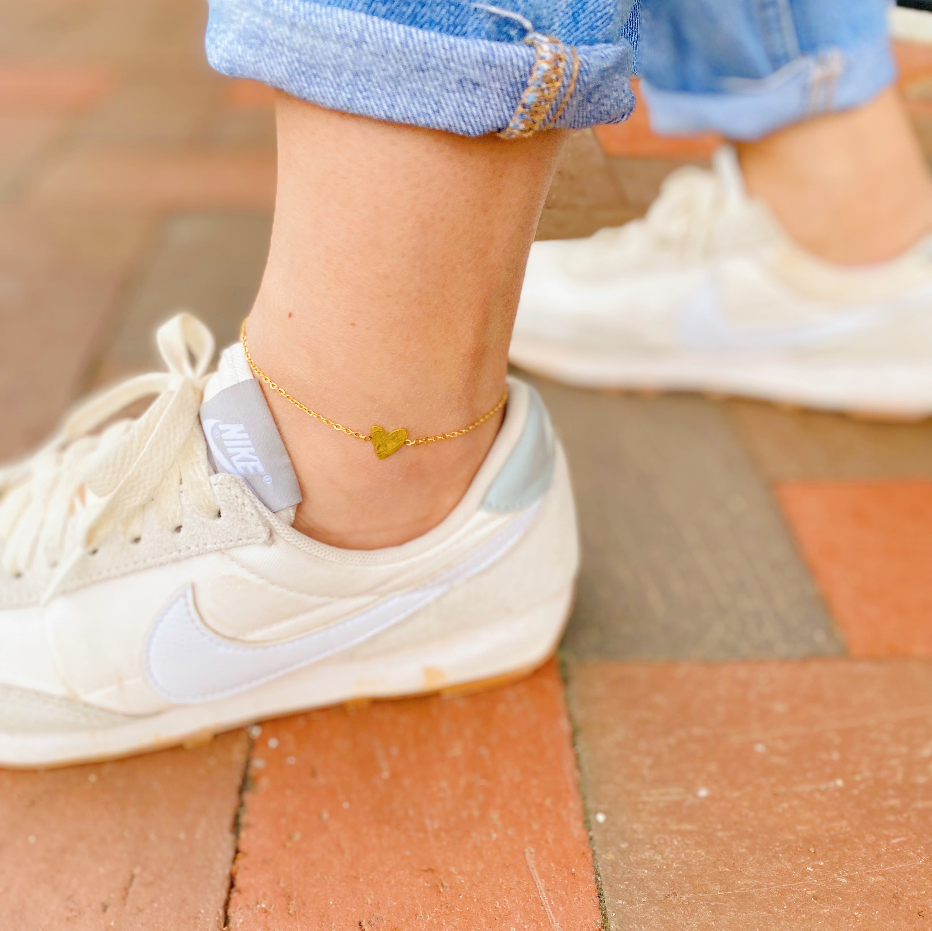 A delicate gold plated stainless steel anklet featuring a polished heart charm, perfect for stylish ankle adornment.