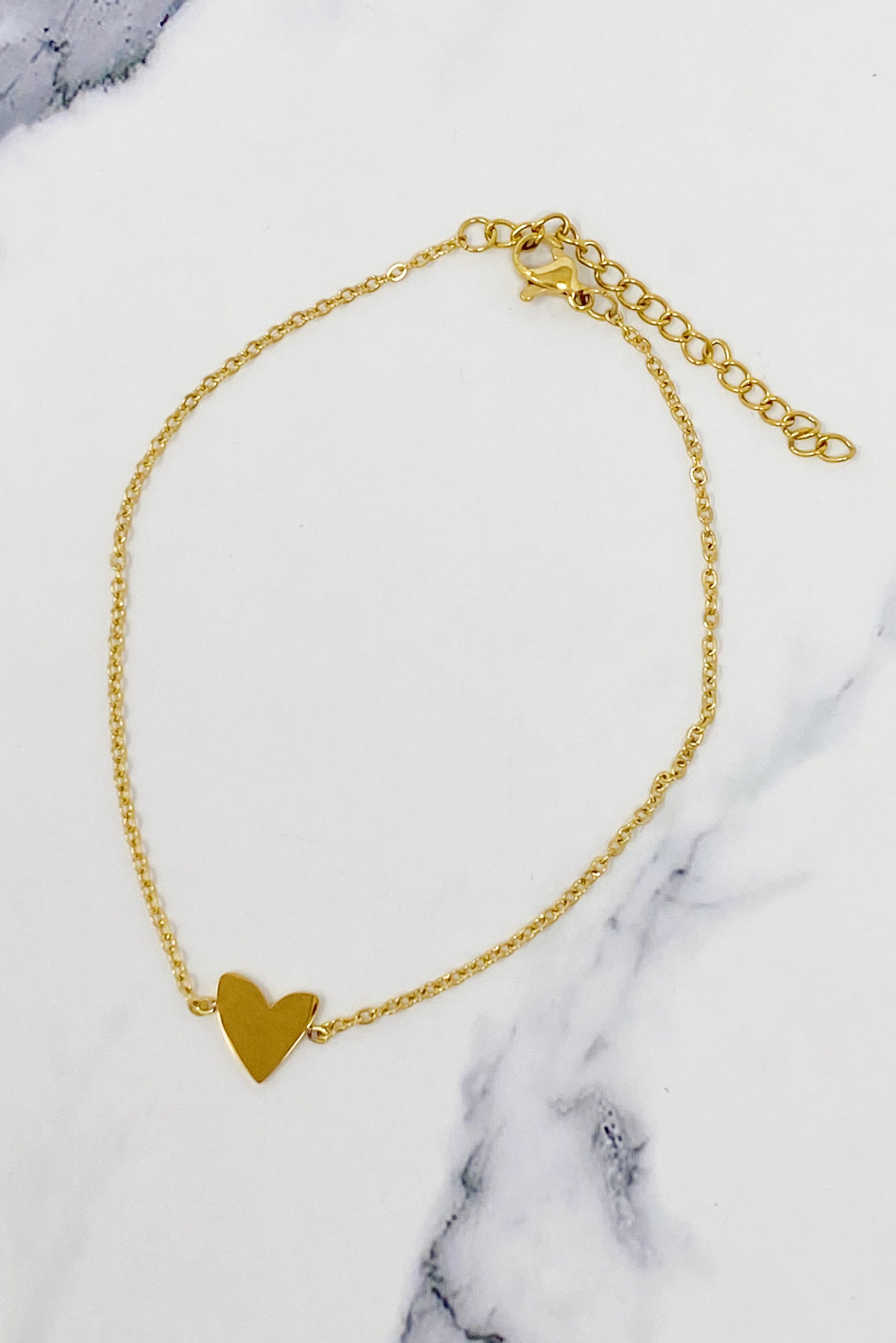 A delicate gold plated stainless steel anklet featuring a polished heart charm, perfect for stylish ankle adornment.