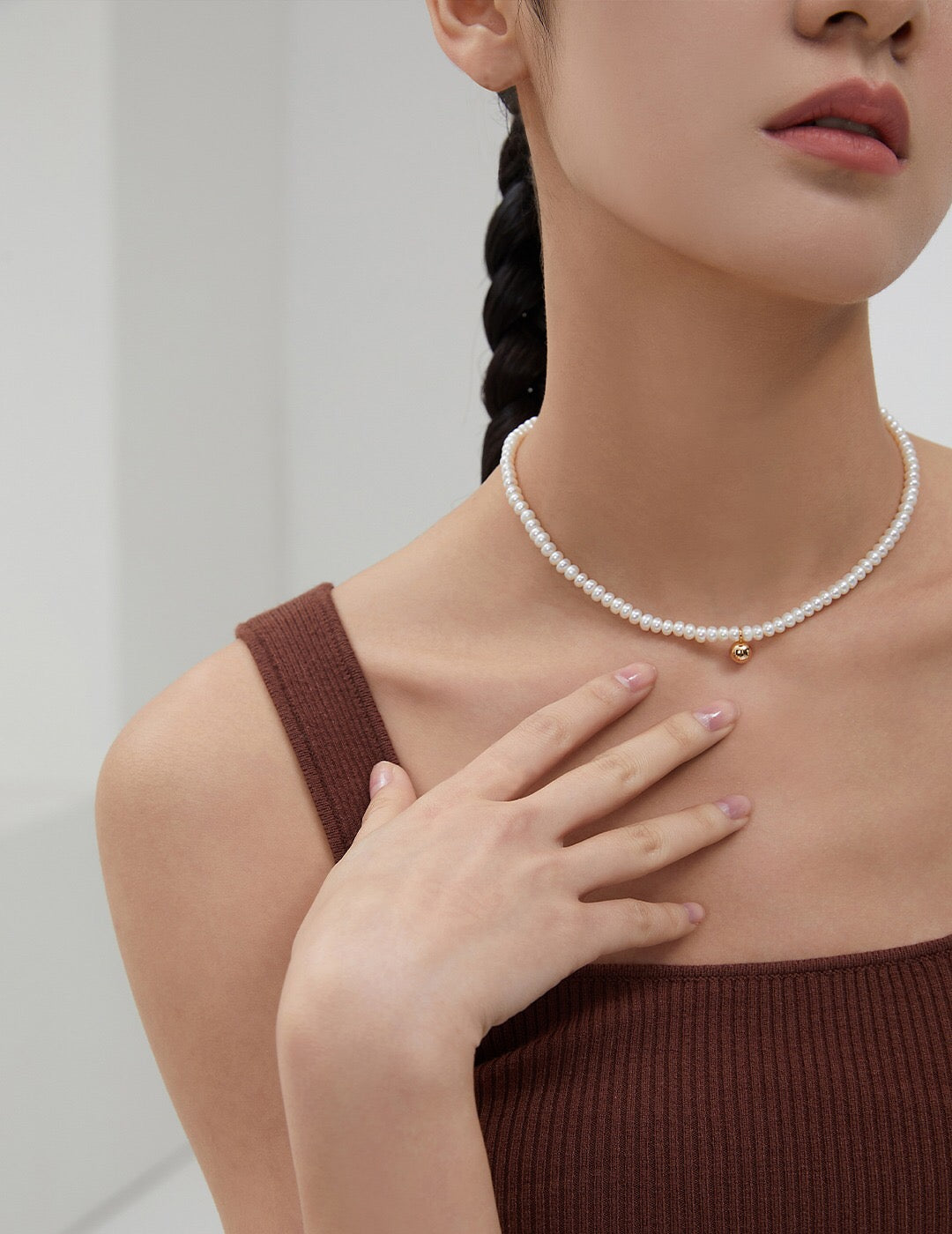 A delicate Dainty Pearl Beaded Necklace featuring natural pearls and gold vermeil, elegantly displayed on a soft fabric background.