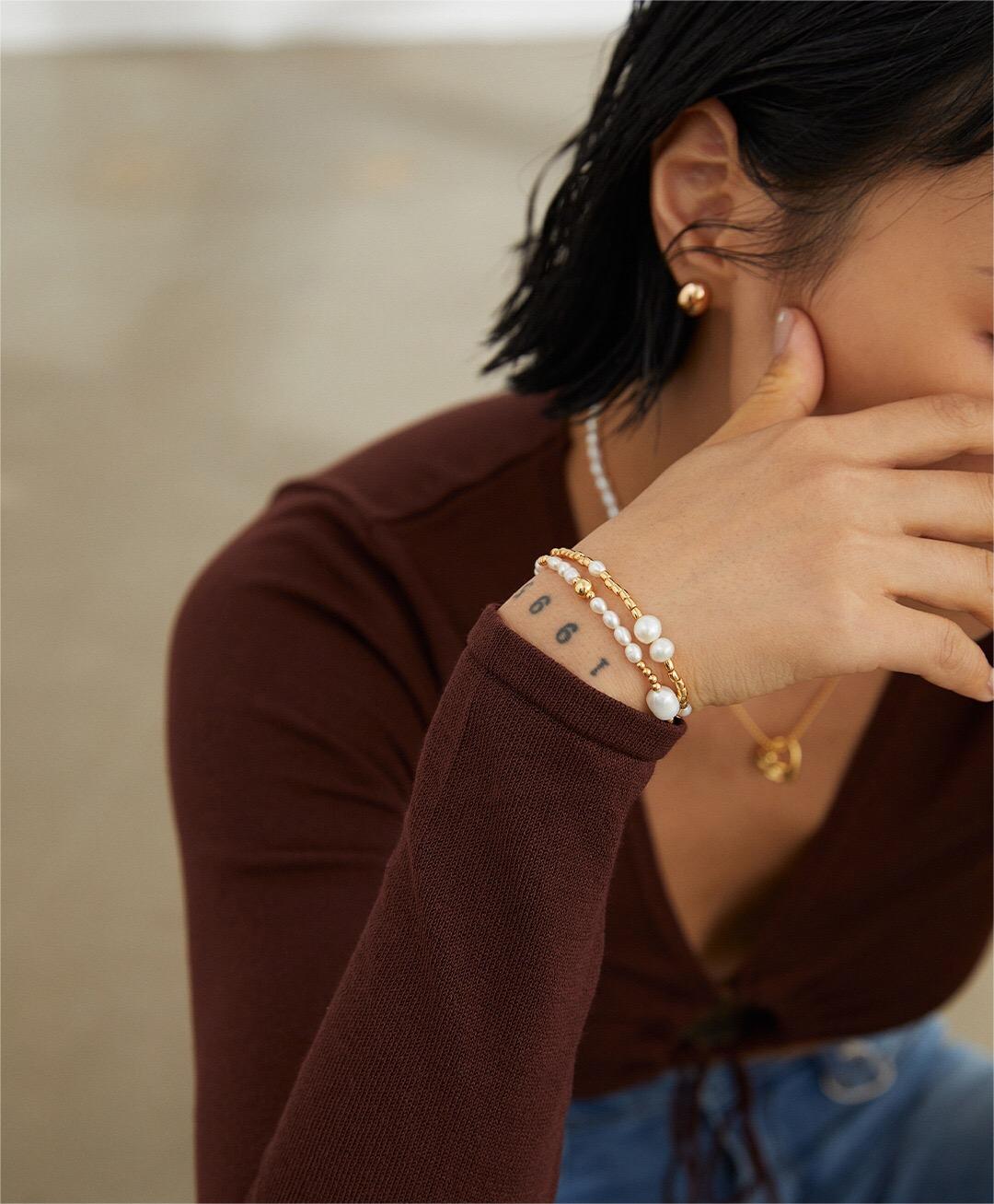 A delicate Dainty Rice Pearl Bracelet featuring Tiger Eye Stone and Gold Vermeil accents, elegantly displayed on a soft surface.