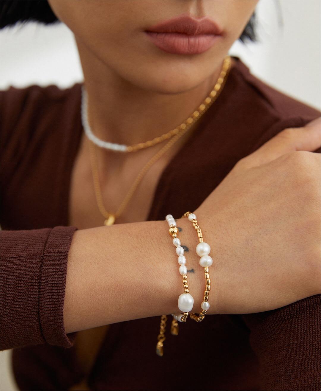 A delicate Dainty Rice Pearl Bracelet featuring Tiger Eye Stone and Gold Vermeil accents, elegantly displayed on a soft surface.