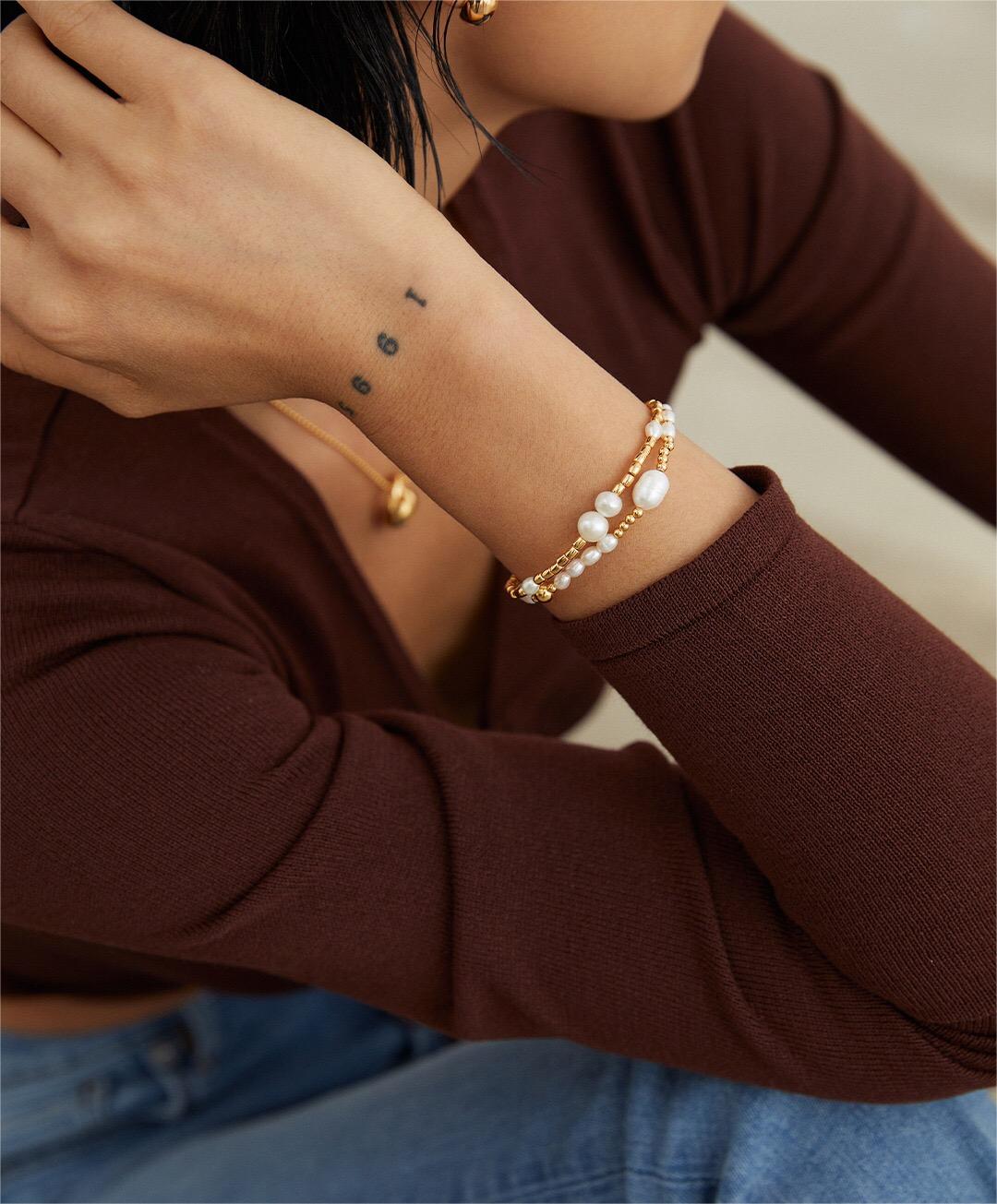 A delicate Dainty Rice Pearl Bracelet featuring Tiger Eye Stone and Gold Vermeil accents, elegantly displayed on a soft surface.