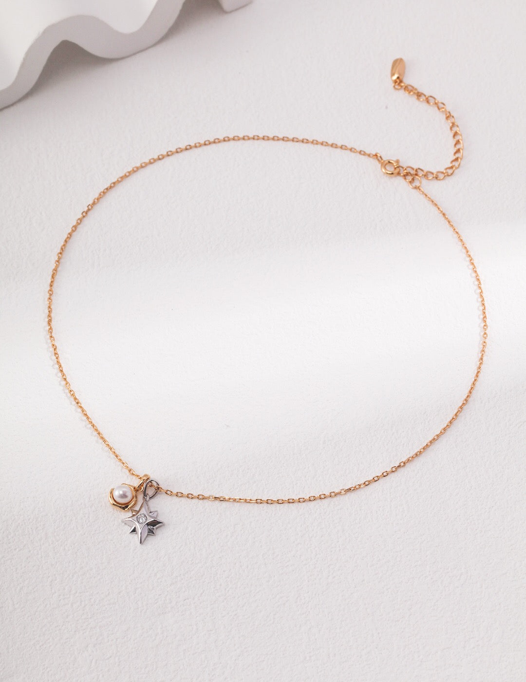 A delicate Dainty Star and Moon Pearl Necklace featuring natural pearls and gold vermeil, showcasing a celestial design.