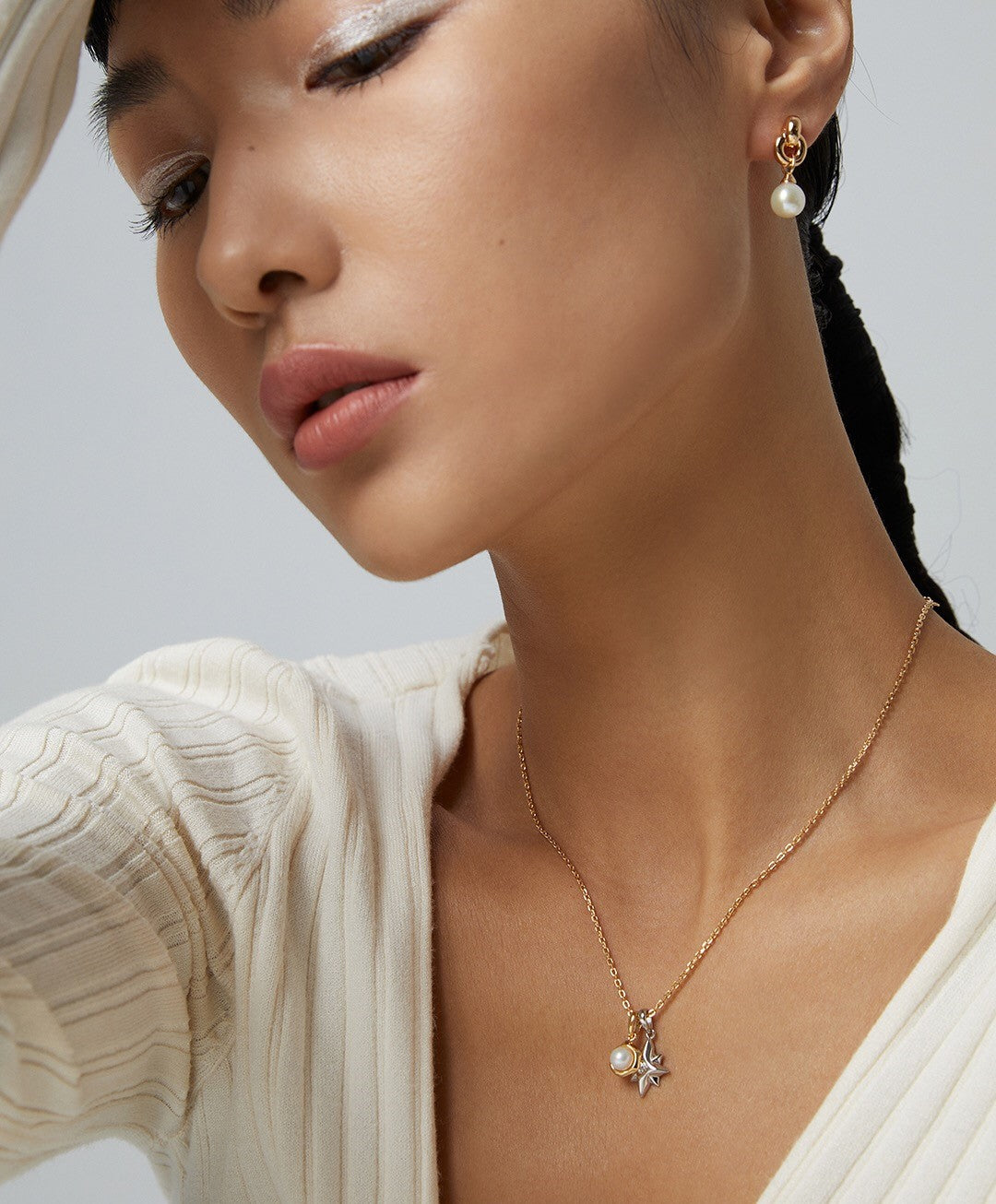 A delicate Dainty Star and Moon Pearl Necklace featuring natural pearls and gold vermeil, showcasing a celestial design.