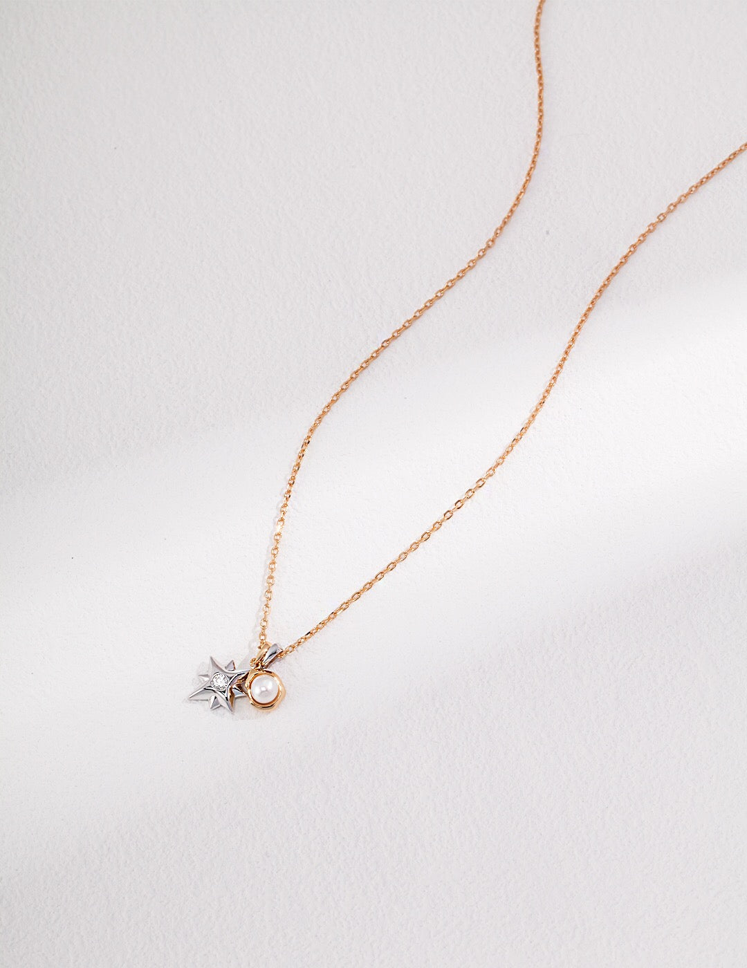 A delicate Dainty Star and Moon Pearl Necklace featuring natural pearls and gold vermeil, showcasing a celestial design.