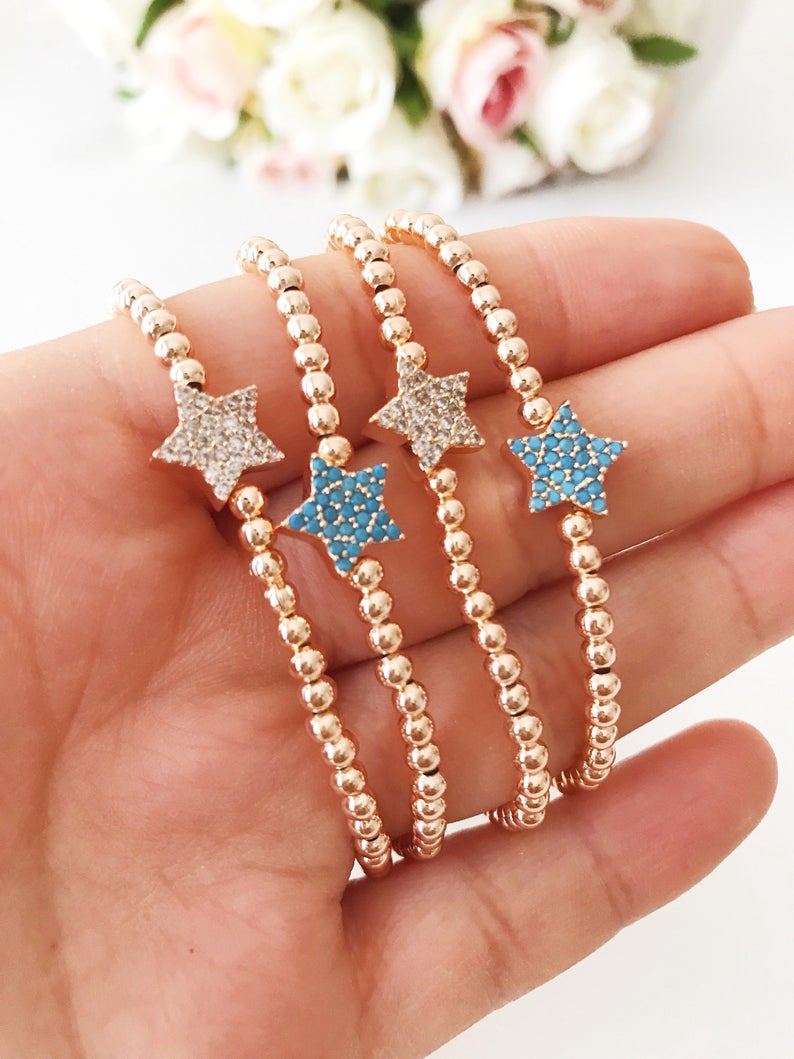 A dainty rose gold bracelet featuring a tiny star charm, adorned with either turquoise or zirconia beads, showcasing its delicate and adjustable design.