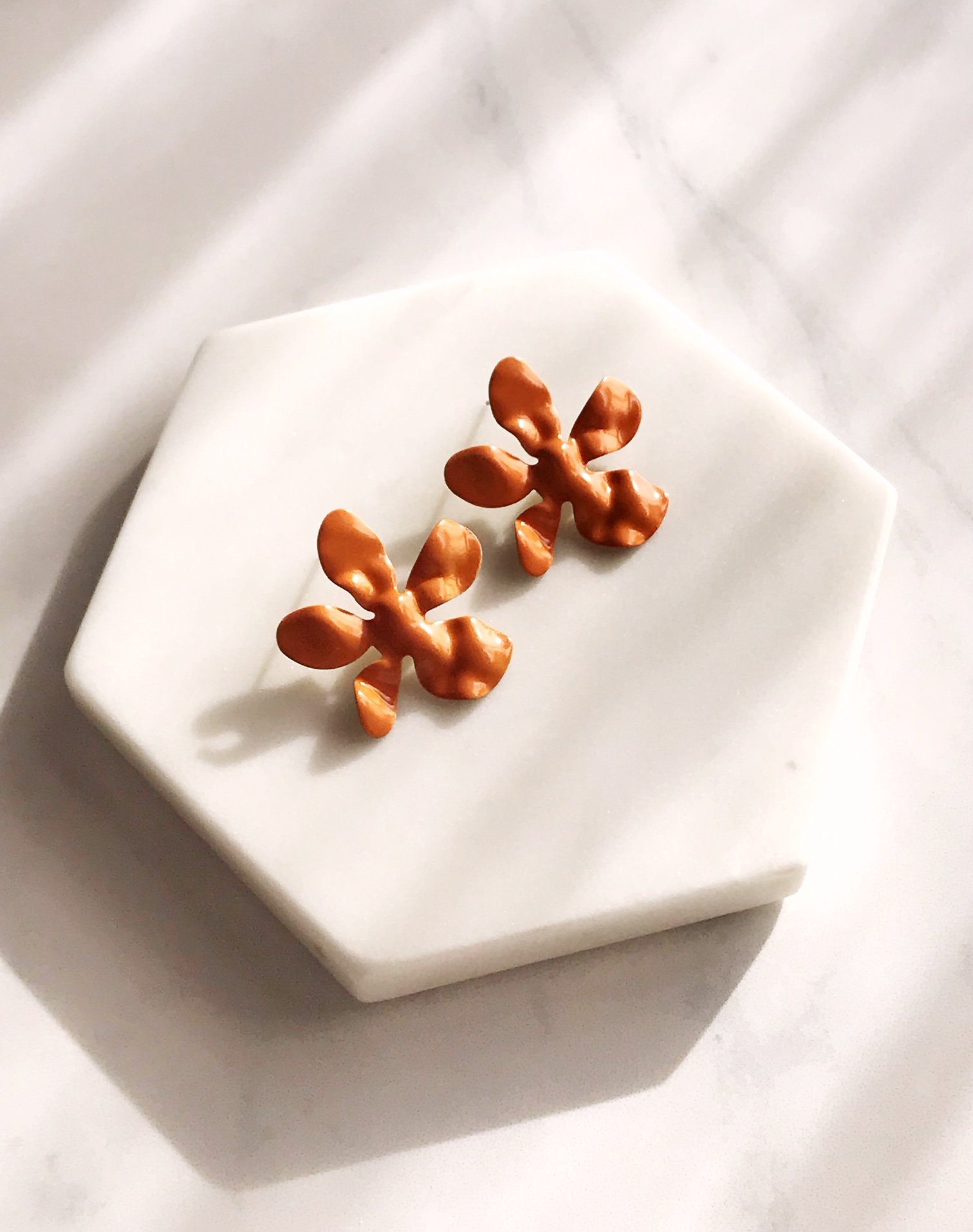 Ivory daisy earrings made of enameled brass with stainless steel ear posts, showcasing a delicate flower design.