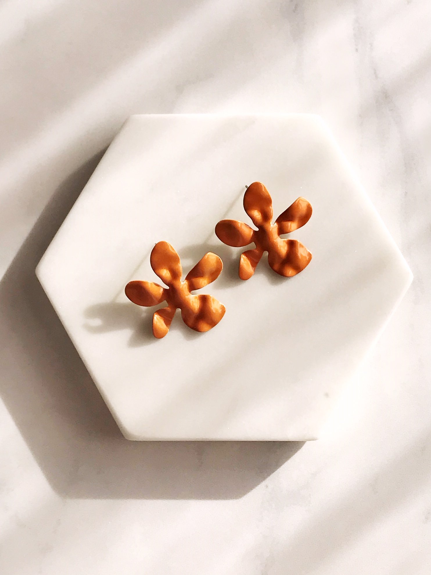 Ivory daisy earrings made of enameled brass with stainless steel ear posts, showcasing a delicate flower design.