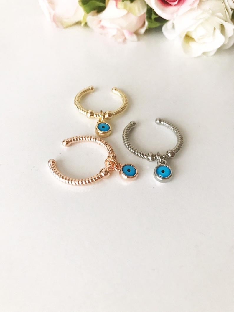 Dangle Evil Eye Ring featuring a blue charm, adjustable band in rose gold, gold, or silver.