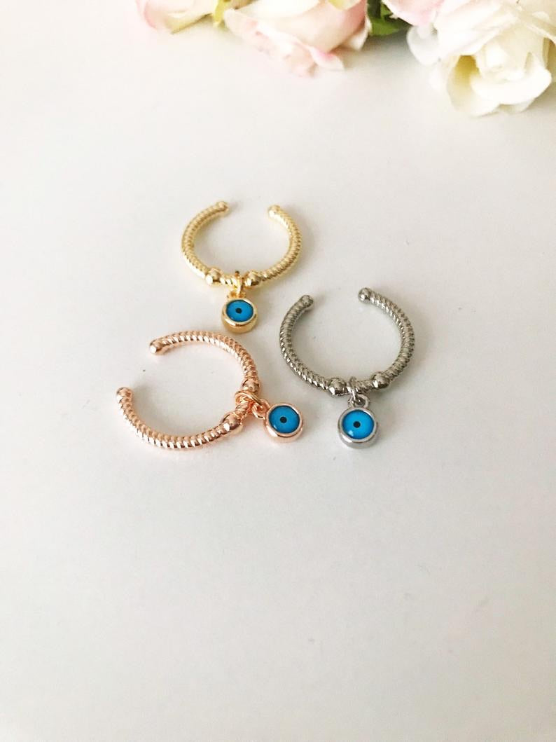 Dangle Evil Eye Ring featuring a blue charm, adjustable band in rose gold, gold, or silver.