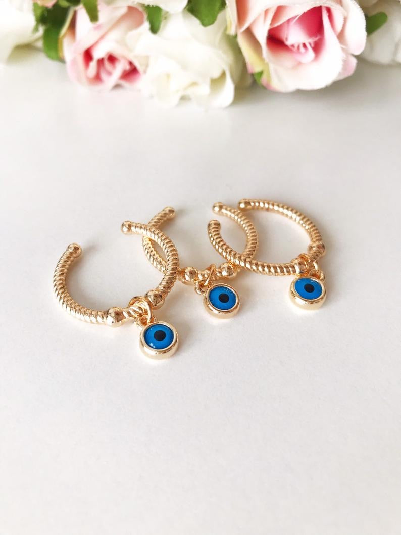 Dangle Evil Eye Ring featuring a blue charm, adjustable band in rose gold, gold, or silver.