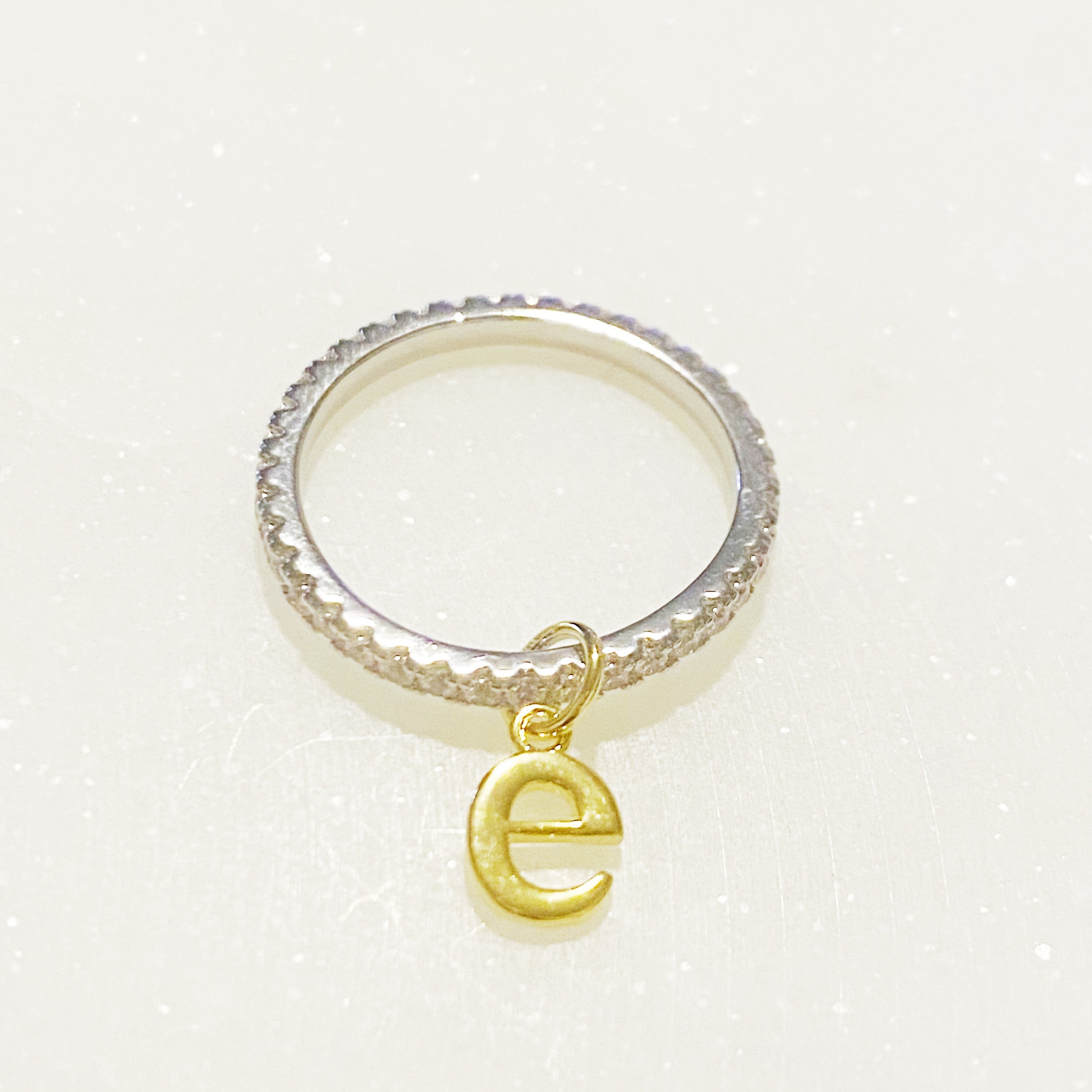 Dangle Initial Ring featuring a gold tone charm and sparkling cubic zirconia accents, elegantly designed for a dainty look.