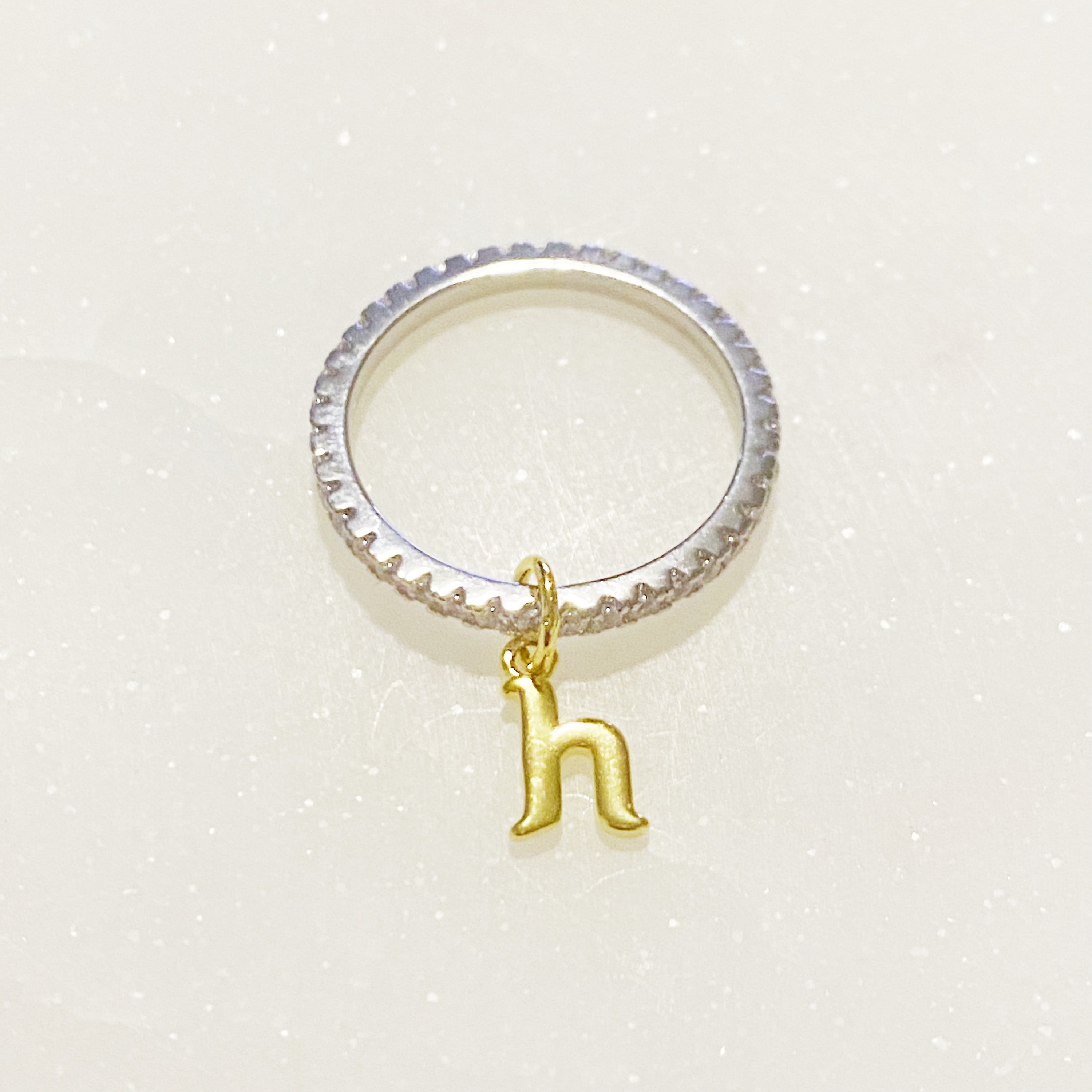 Dangle Initial Ring featuring a gold tone charm and sparkling cubic zirconia accents, elegantly designed for a dainty look.