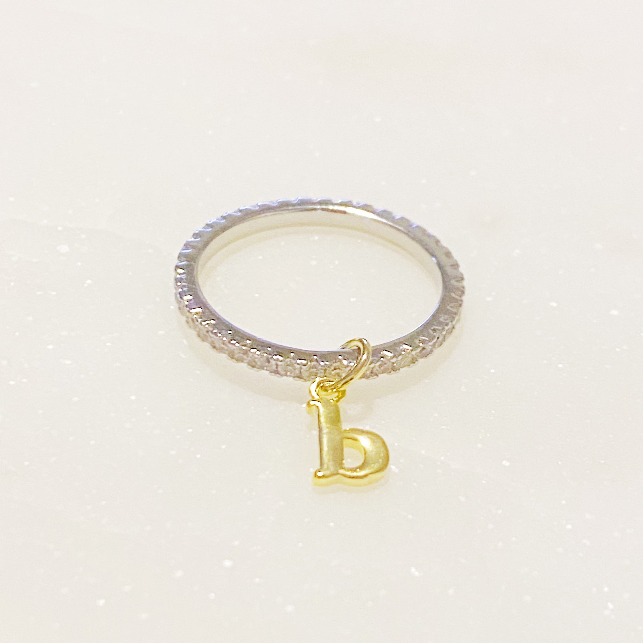 Dangle Initial Ring featuring a gold tone charm and sparkling cubic zirconia accents, elegantly designed for a dainty look.