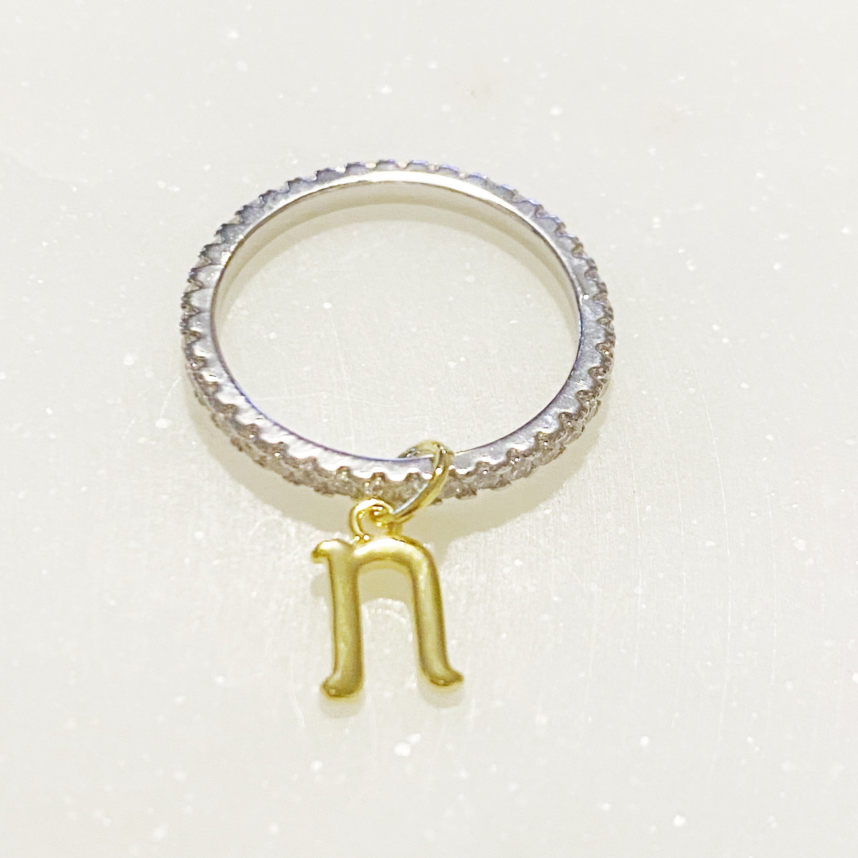 Dangle Initial Ring featuring a gold tone charm and sparkling cubic zirconia accents, elegantly designed for a dainty look.