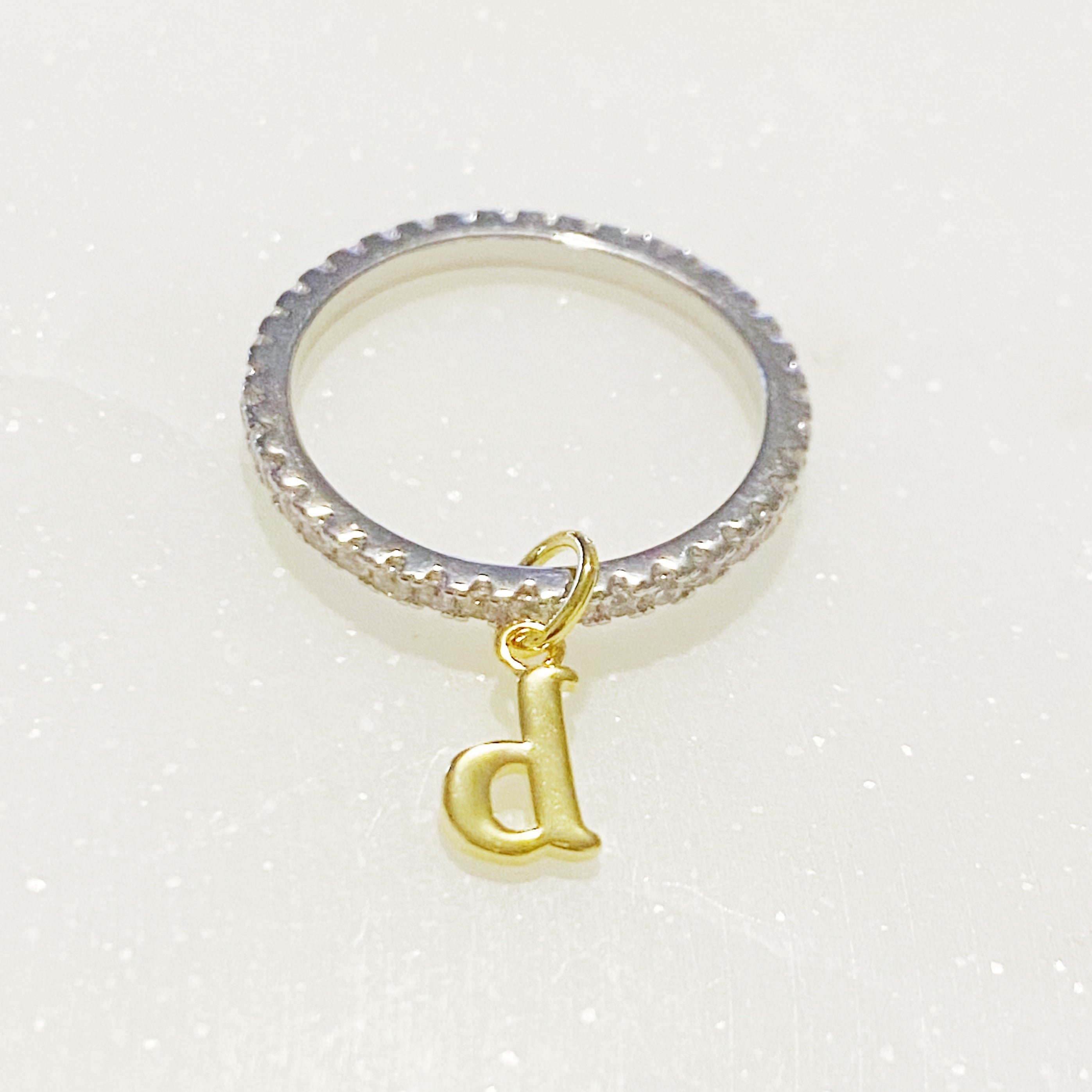 Dangle Initial Ring featuring a gold tone charm and sparkling cubic zirconia accents, elegantly designed for a dainty look.