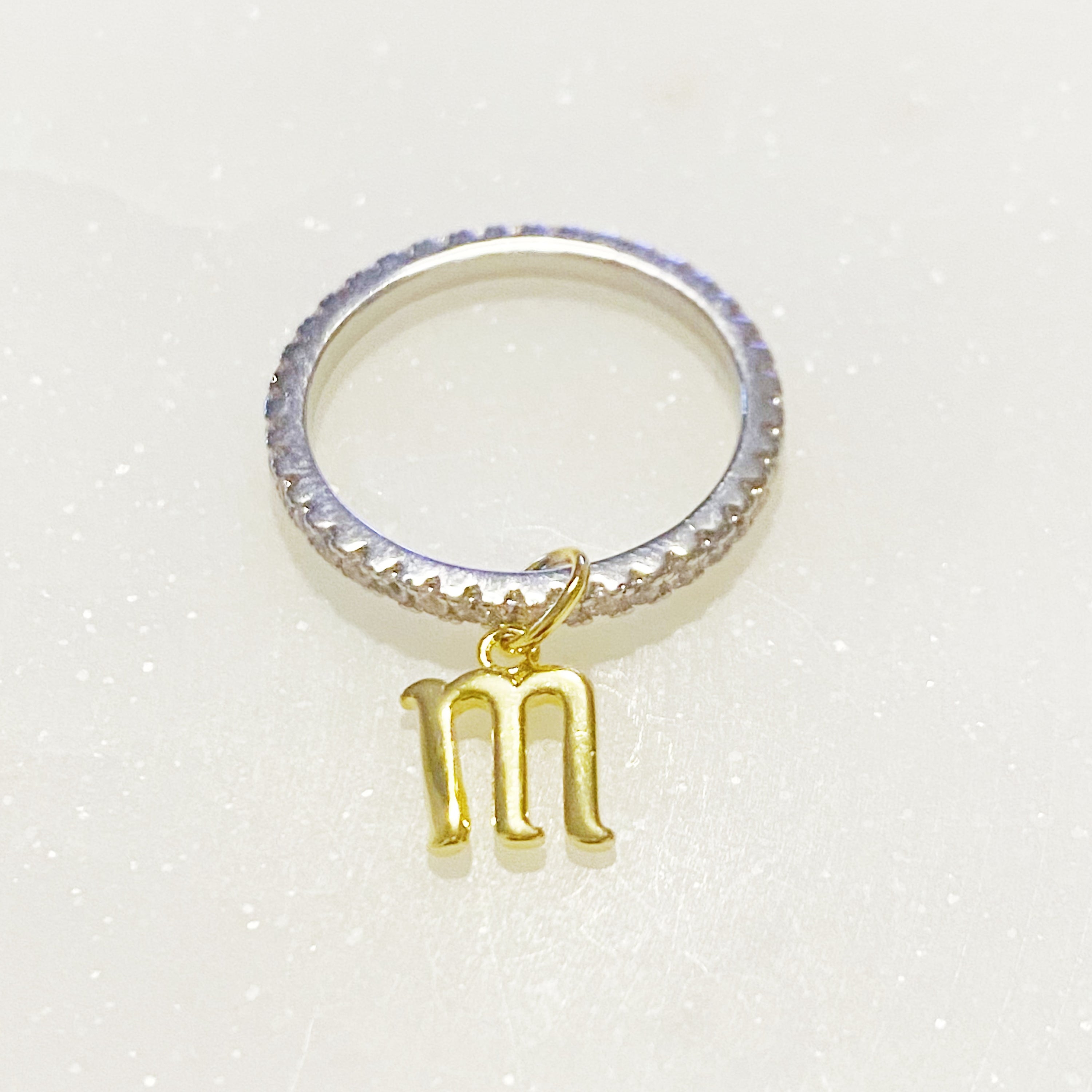 Dangle Initial Ring featuring a gold tone charm and sparkling cubic zirconia accents, elegantly designed for a dainty look.