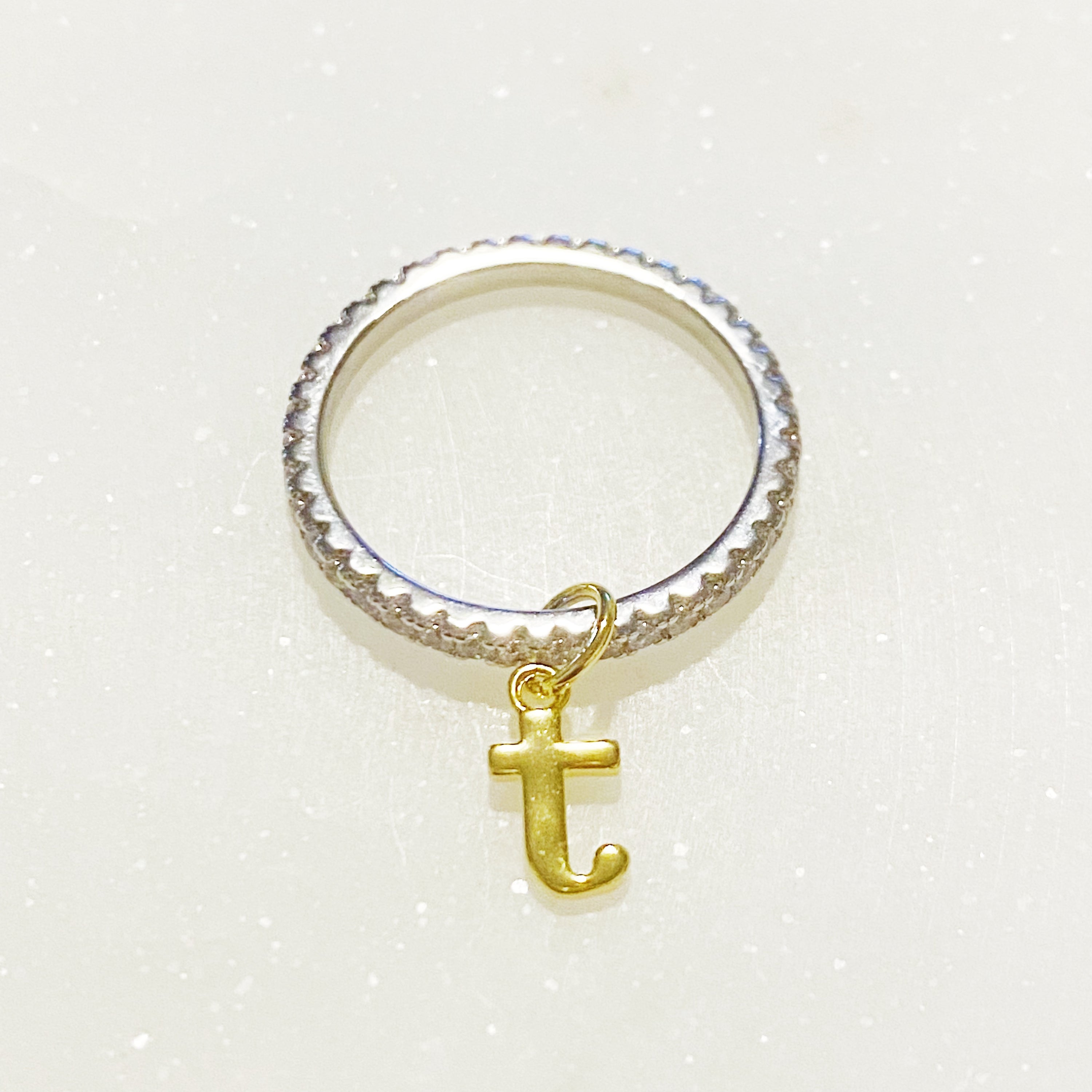 Dangle Initial Ring featuring a gold tone charm and sparkling cubic zirconia accents, elegantly designed for a dainty look.