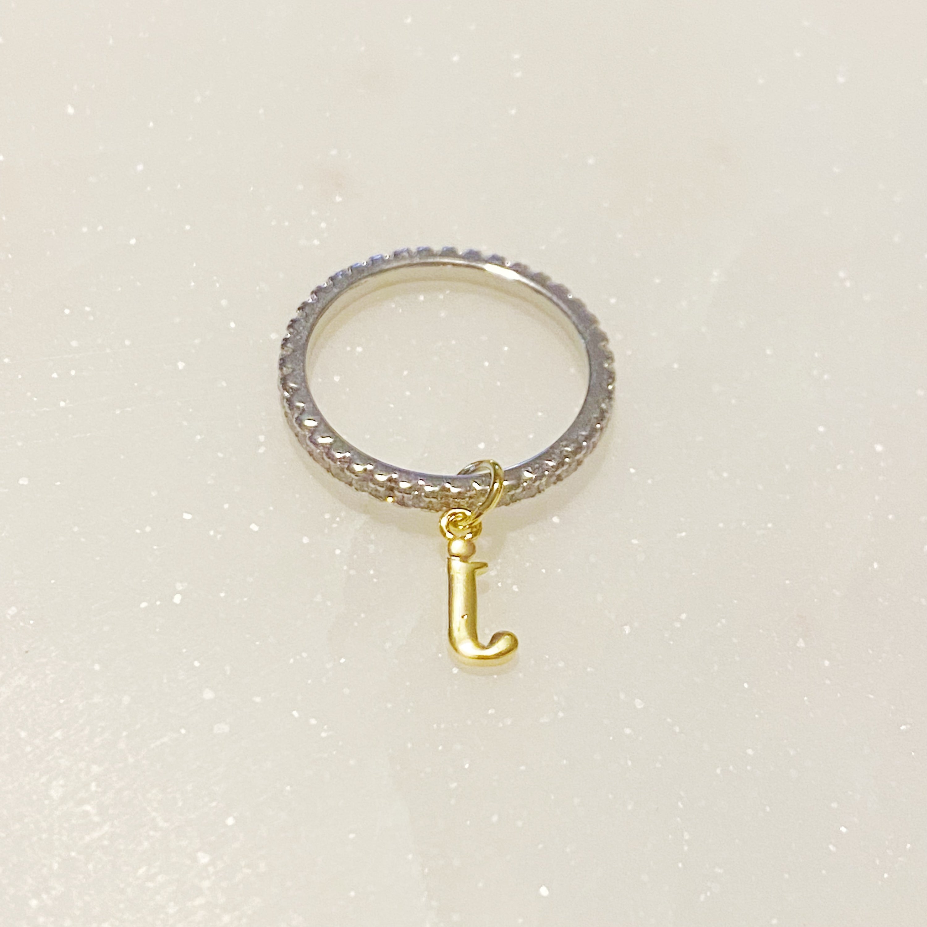 Dangle Initial Ring featuring a gold tone charm and sparkling cubic zirconia accents, elegantly designed for a dainty look.