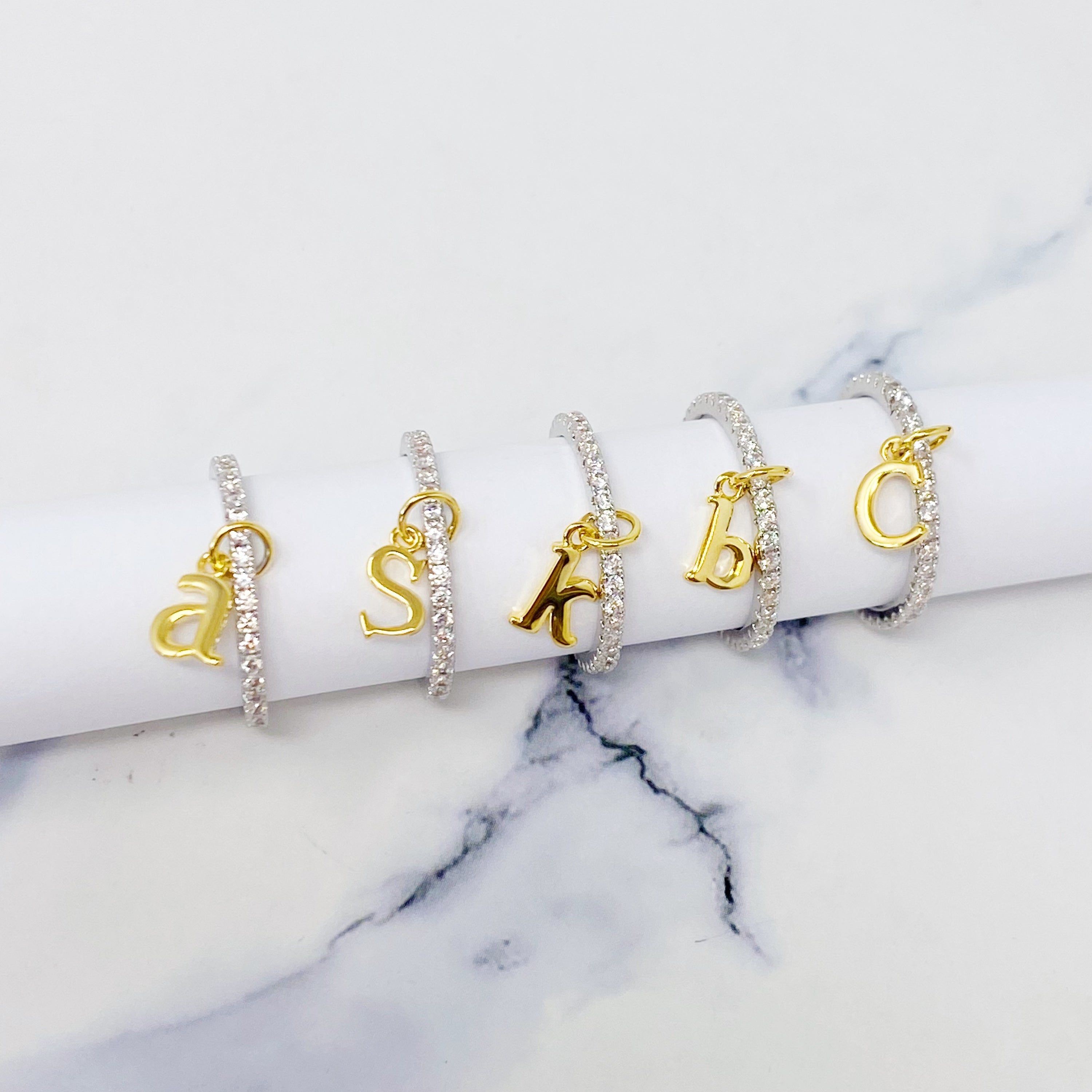 Dangle Initial Ring featuring a gold tone charm and sparkling cubic zirconia accents, elegantly designed for a dainty look.