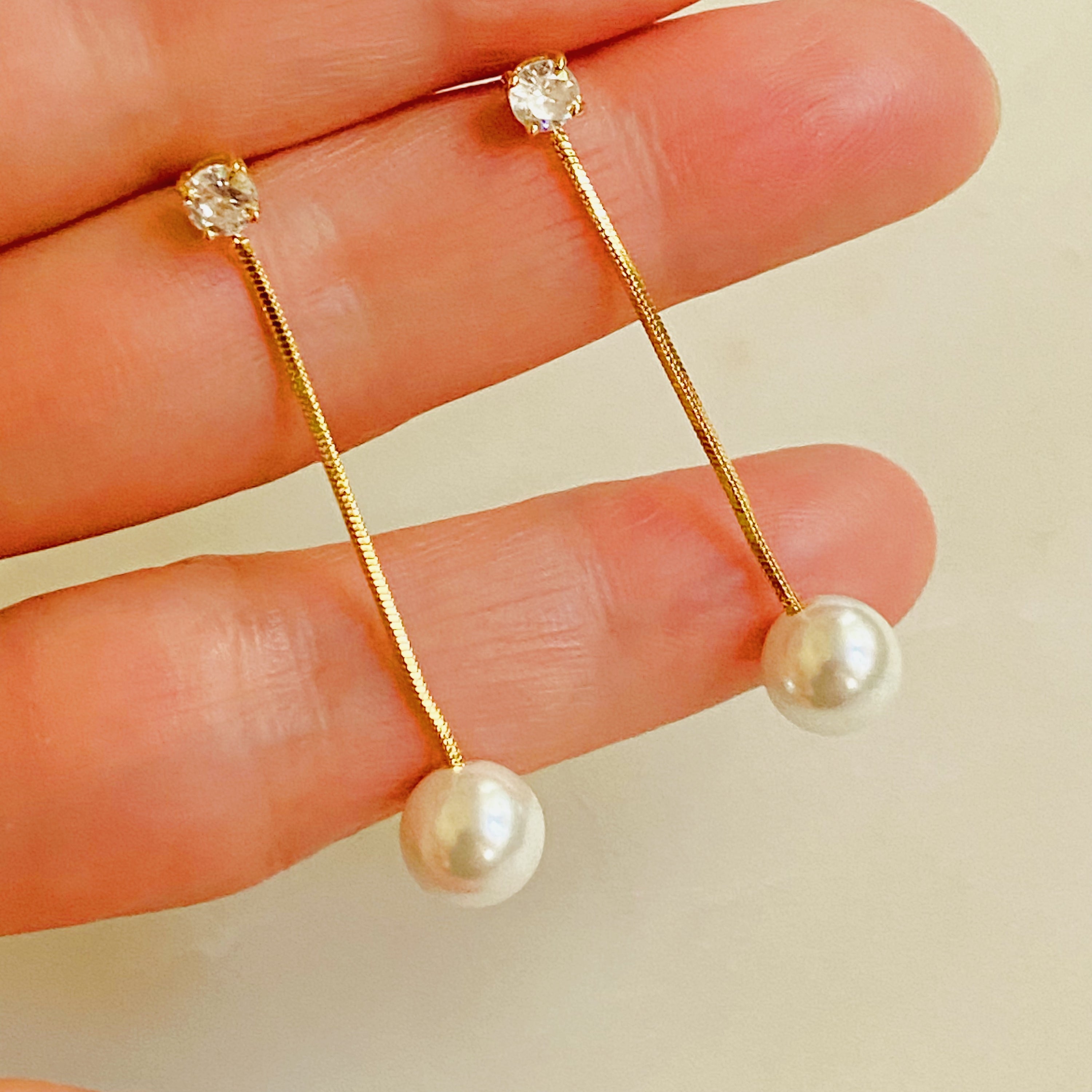 Elegant Dangling Pearl Earring featuring a glass pearl and sparkling Cubic Zirconia, crafted from 18k gold plated brass.