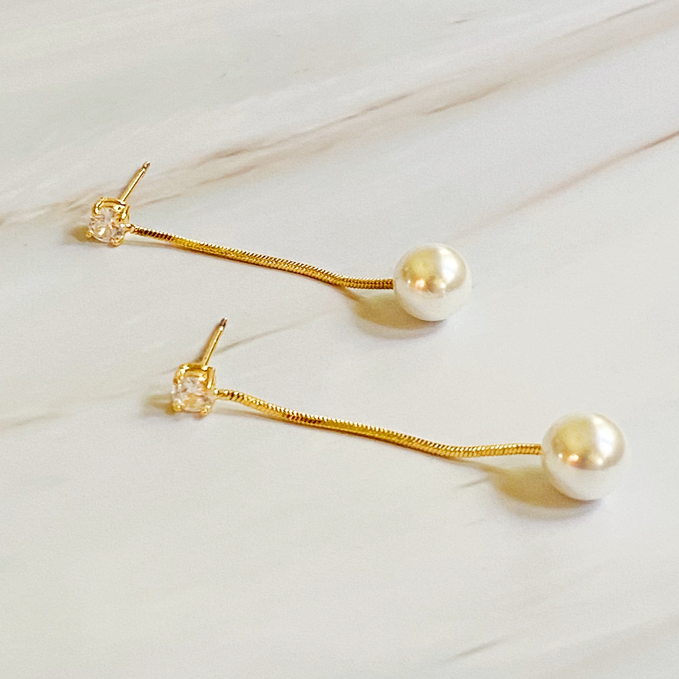 Elegant Dangling Pearl Earring featuring a glass pearl and sparkling Cubic Zirconia, crafted from 18k gold plated brass.