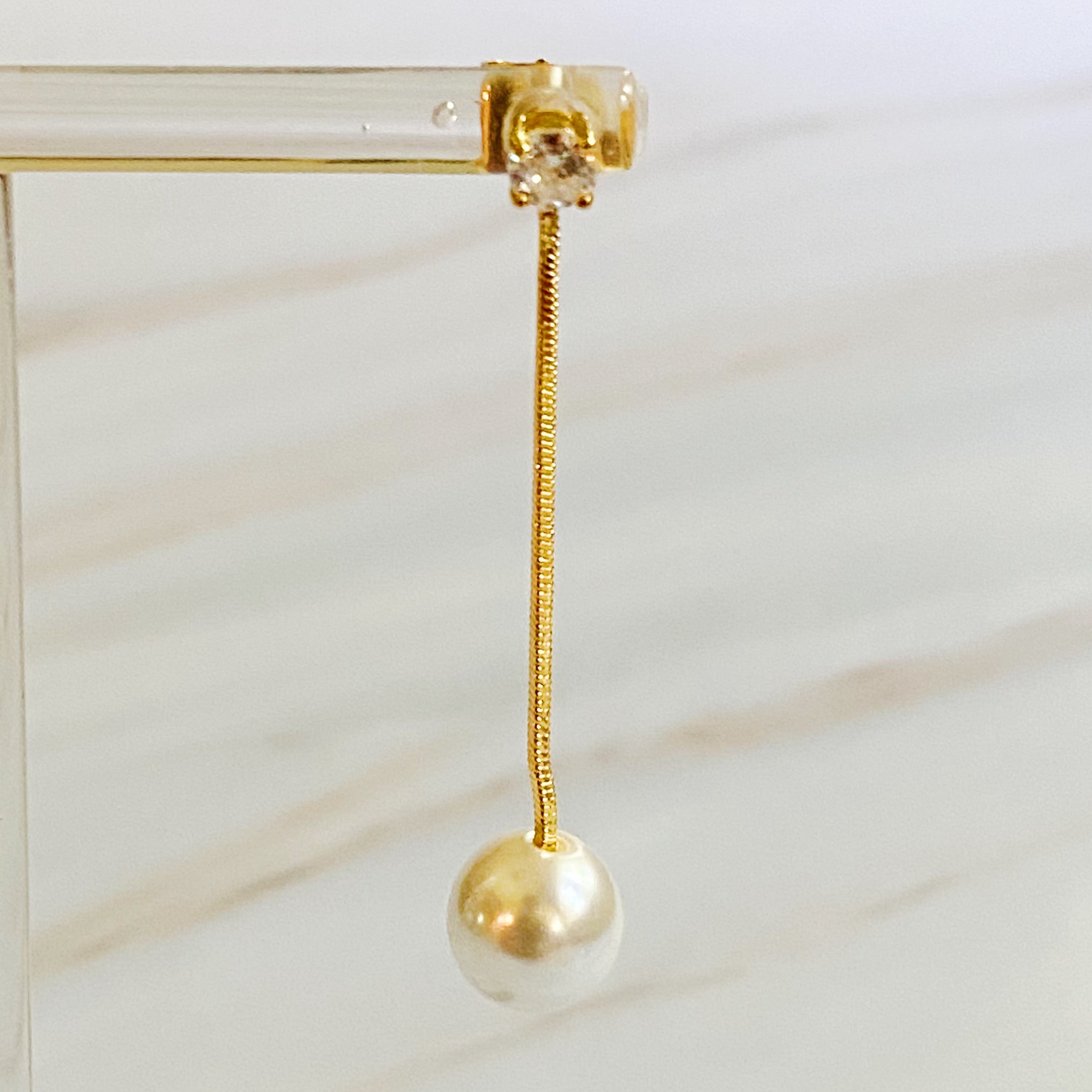 Elegant Dangling Pearl Earring featuring a glass pearl and sparkling Cubic Zirconia, crafted from 18k gold plated brass.