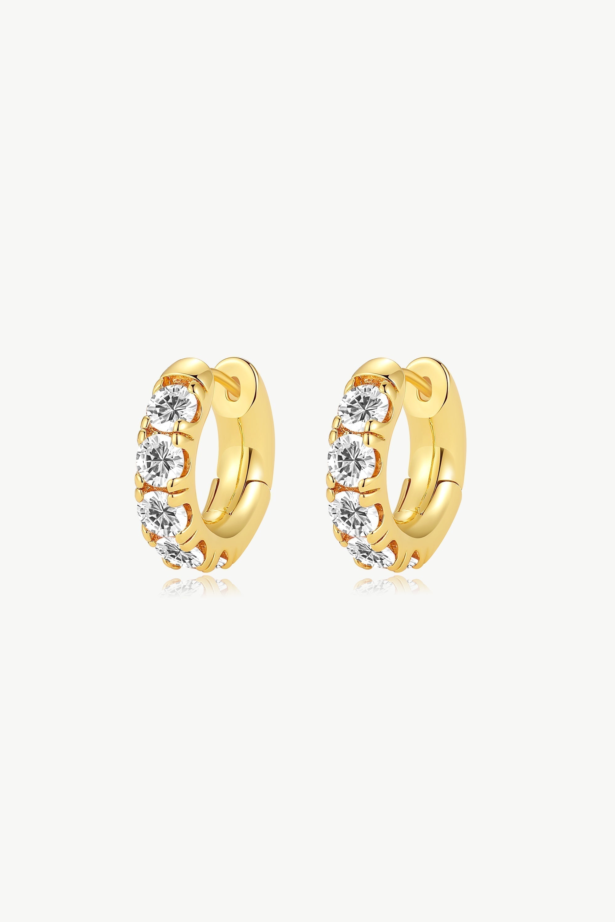 A pair of Daniela Gold Huggie Hoop Earrings featuring Onyx Black Zirconia stones, elegantly designed for pierced ears.