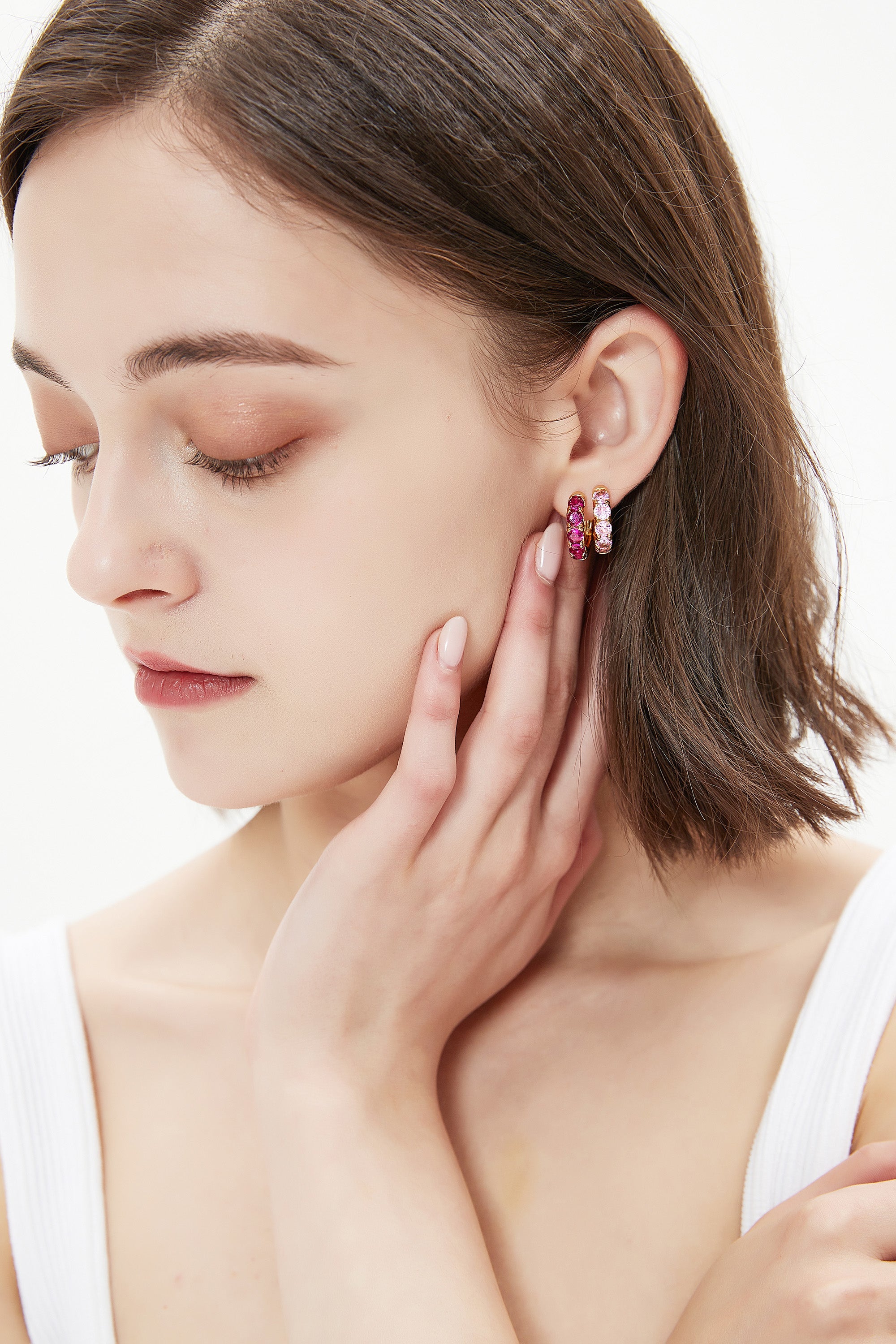 Daniela Gold Huggie Hoop Earrings featuring pink zirconia stones, elegantly designed for pierced ears.