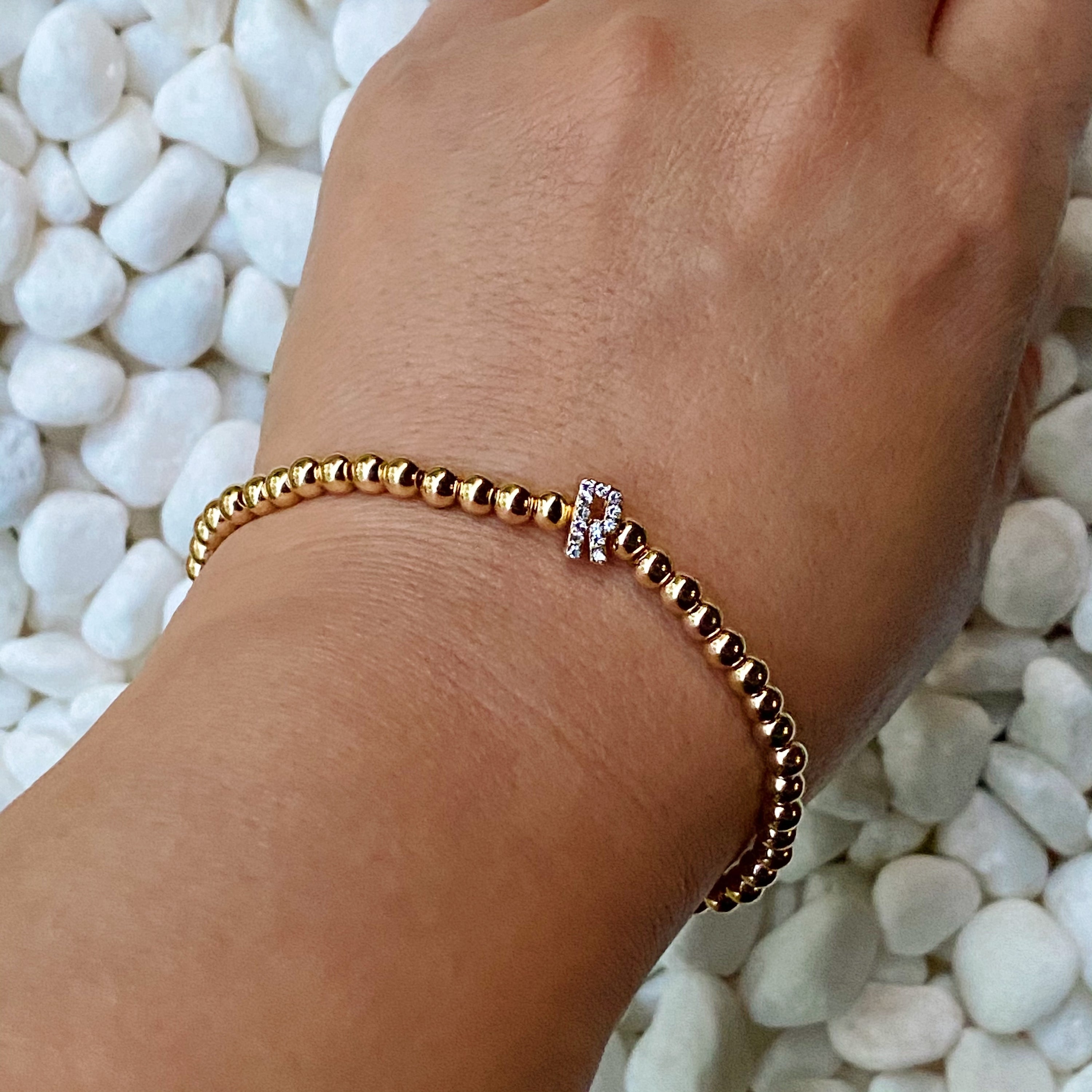 Darcy Initial Bracelet featuring gold tone ball beads and a sparkly initial accent, perfect for layering.