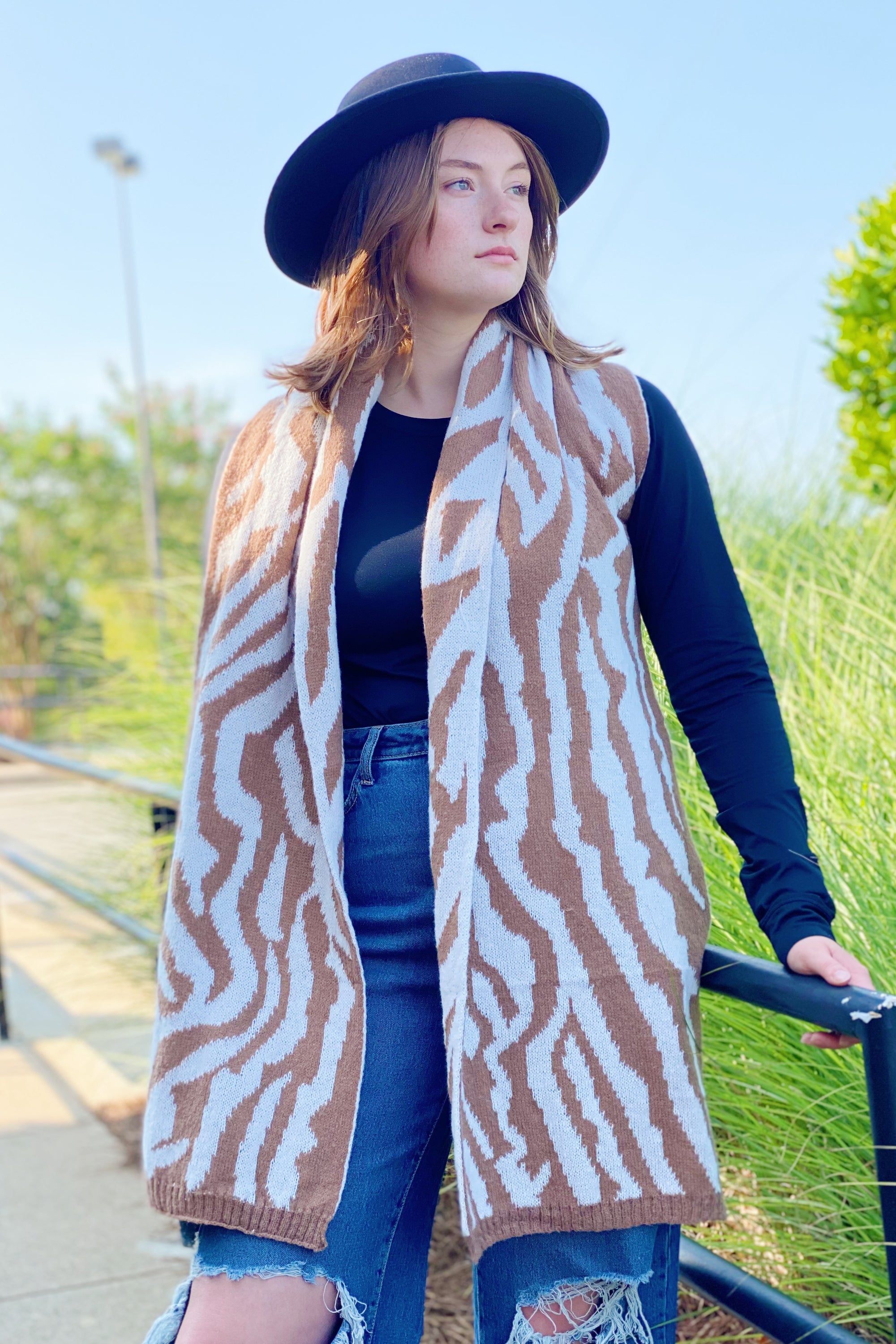 A cozy knit scarf featuring a trendy zebra pattern, reversible for versatile styling, measuring approximately 13 inches by 78 inches.