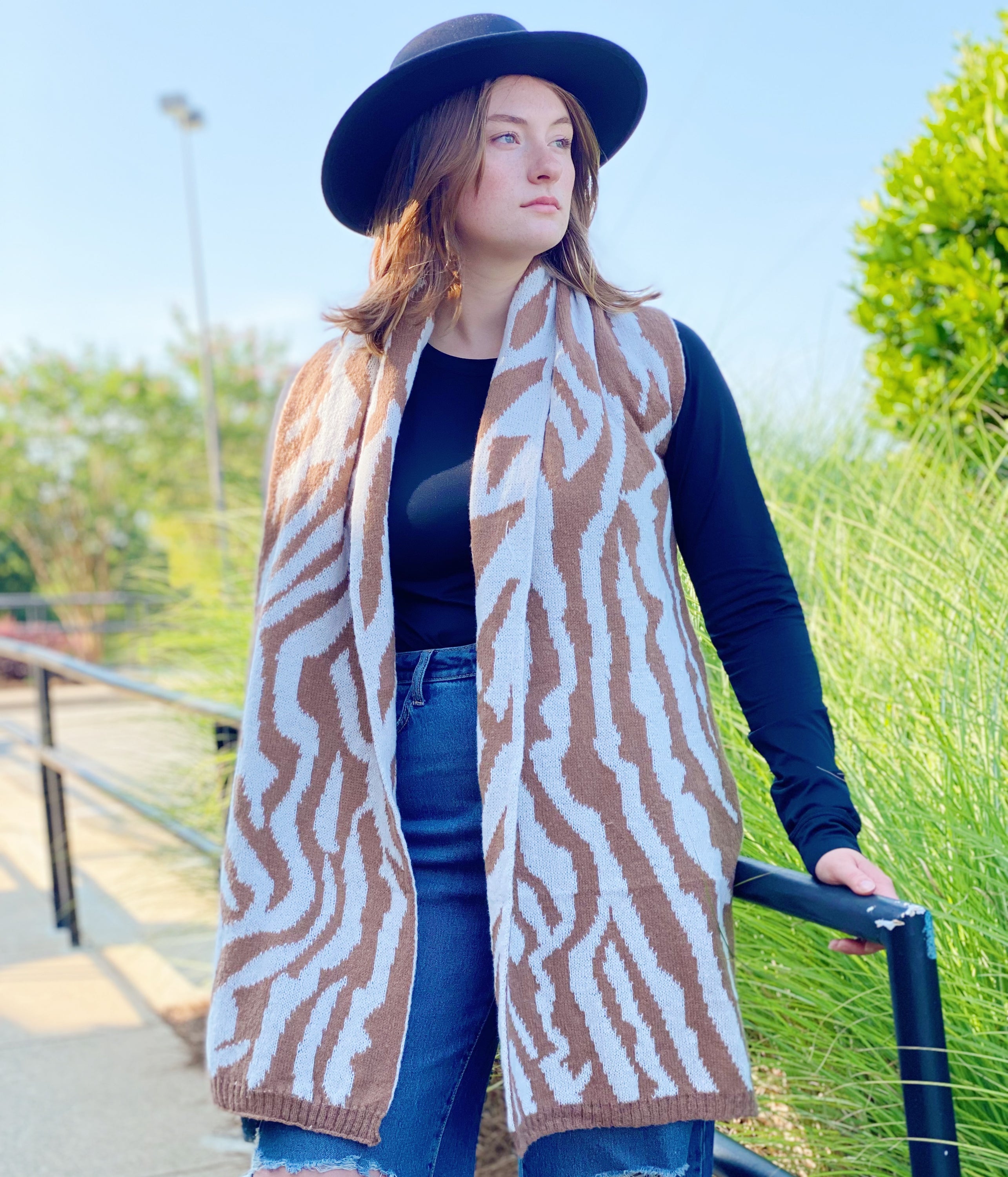 A cozy knit scarf featuring a trendy zebra pattern, reversible for versatile styling, measuring approximately 13 inches by 78 inches.